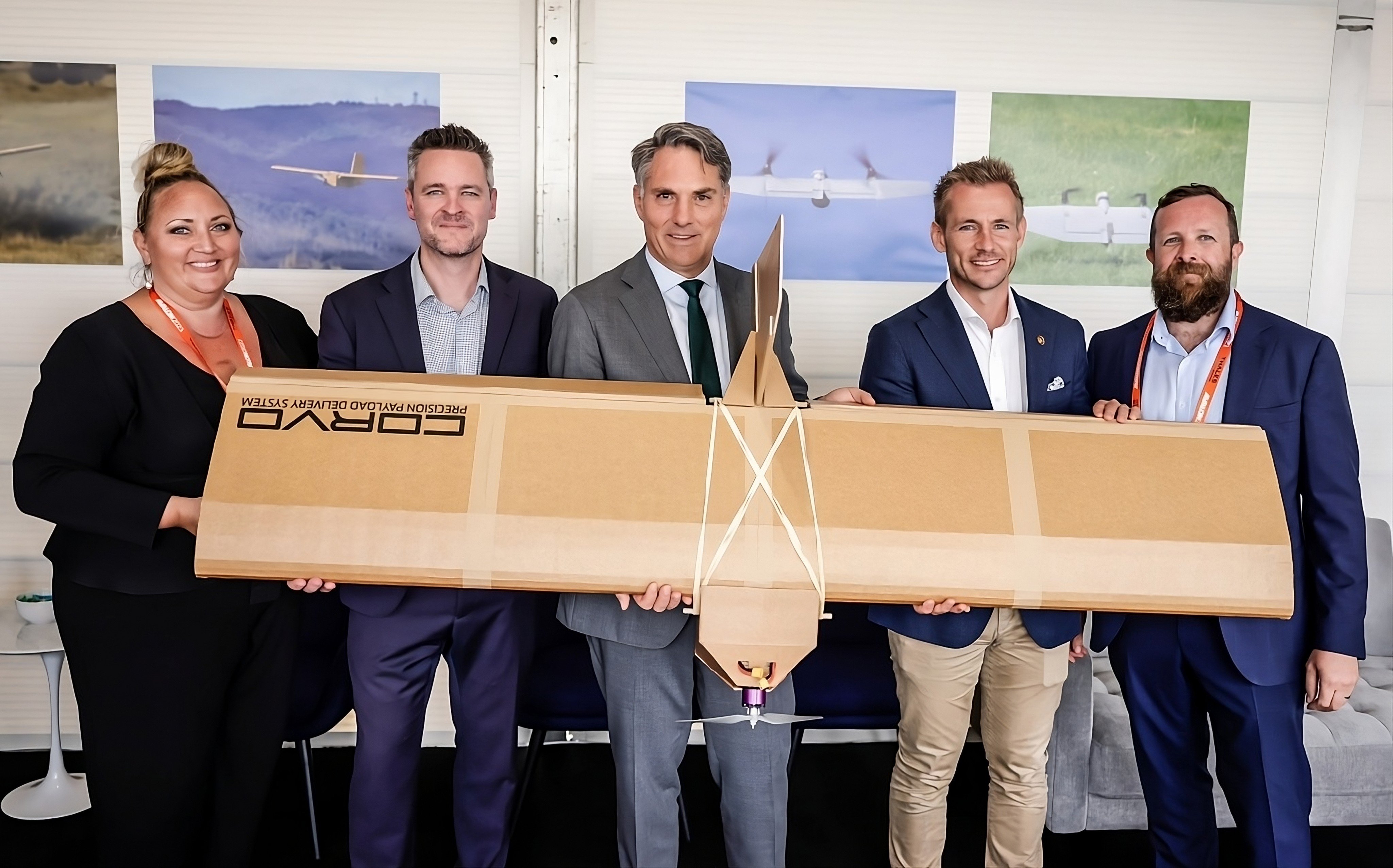 Australian Defence Minister Richard Marles (centre) with staff from Australian defence manufacturer SYPAQ and an example of the Corvo Precision Payload Delivery System drones it developed for Ukraine. Photo: SYPAQ/Handout