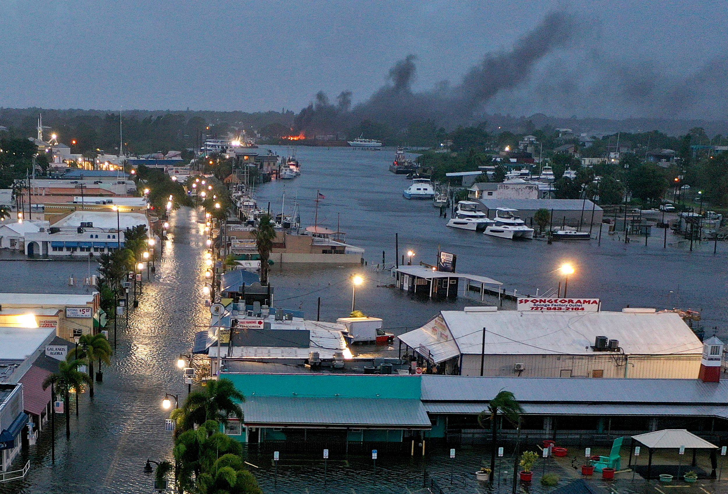 A fire is seen as flood waters inundate downtown Tarpon Springs, Florida after Hurricane Idalia passes offshore. Photo: AFP