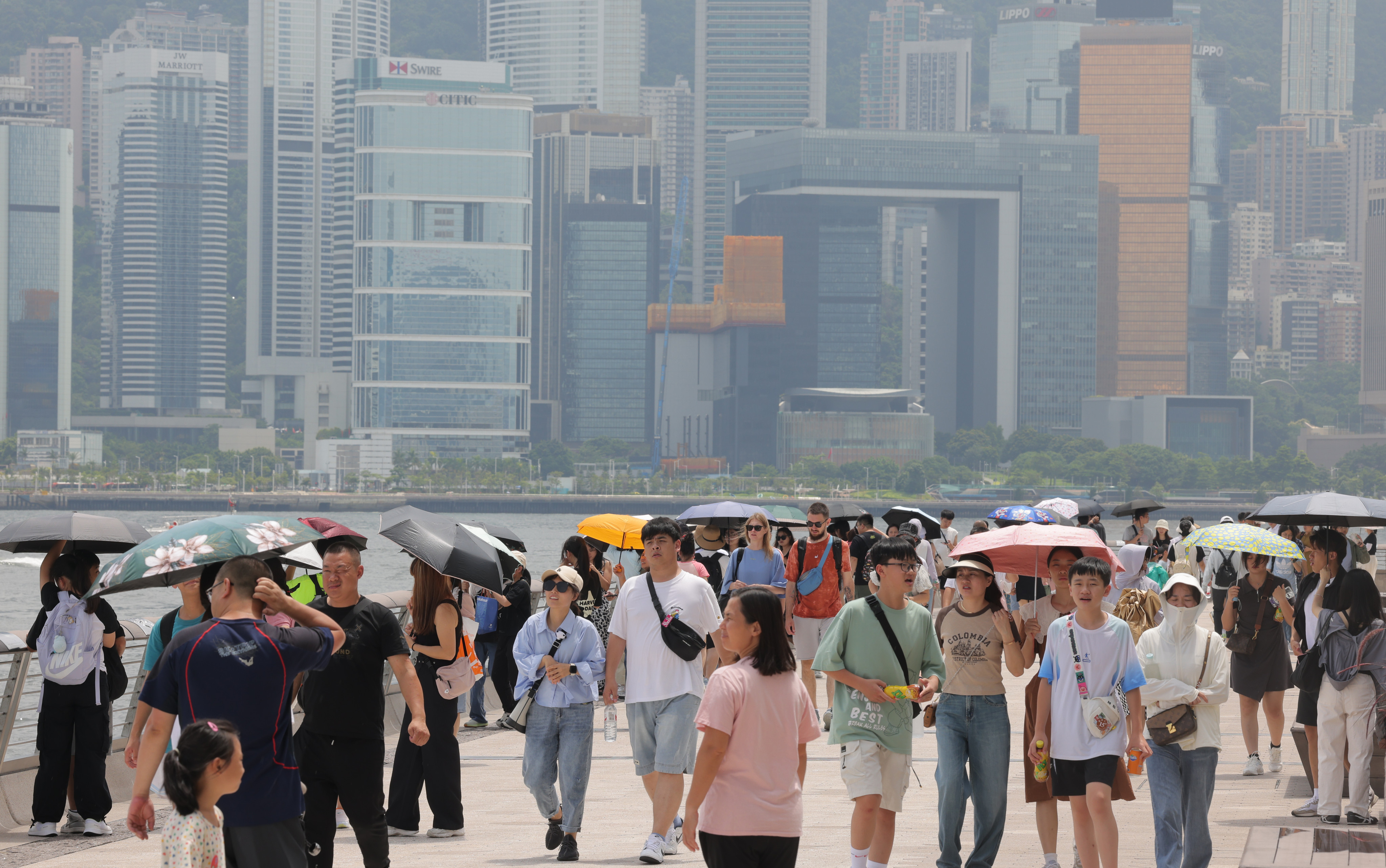 Tourists walk along the waterfront in Tsim Sha Tsui. 10 million travellers from mainland China visited Hong Kong in the first half, pushing up insurance sales. Photo: Jelly Tse