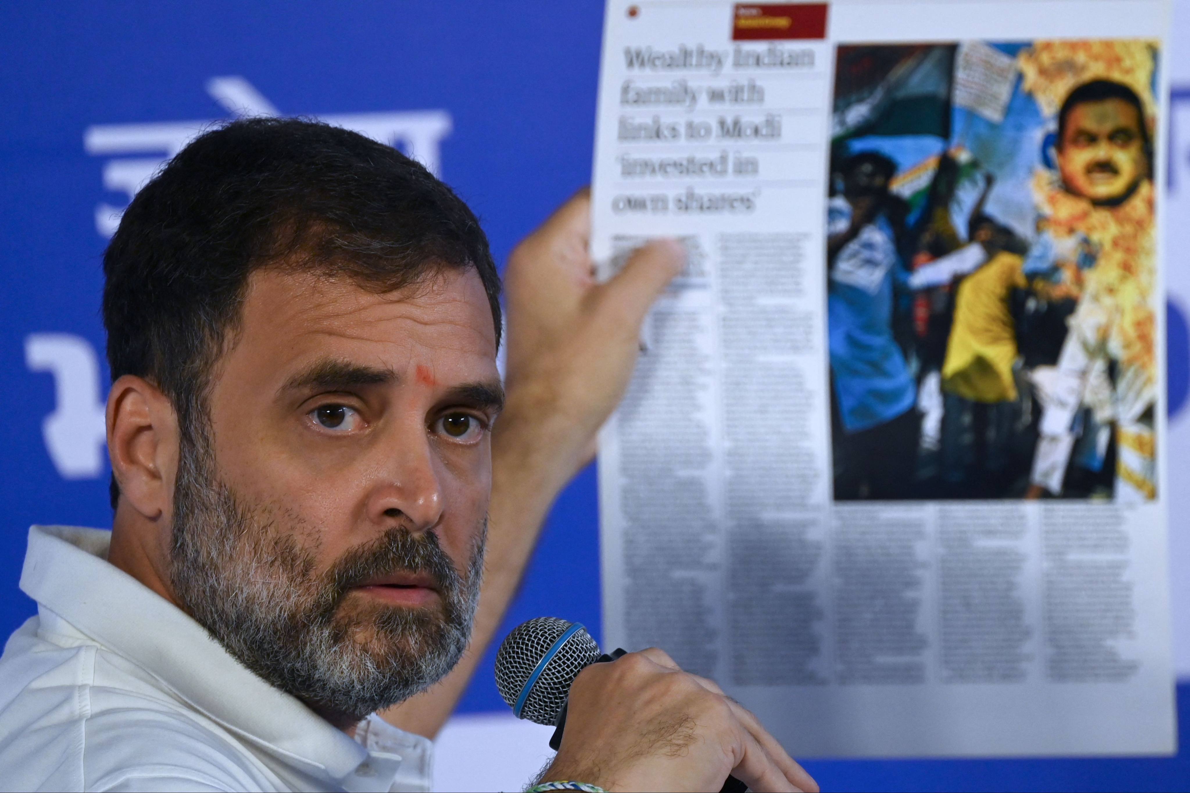 India’s Congress Party leader Rahul Gandhi holds a printout of a report on Gautam Adani in Mumbai on August 31. Photo: AFP 