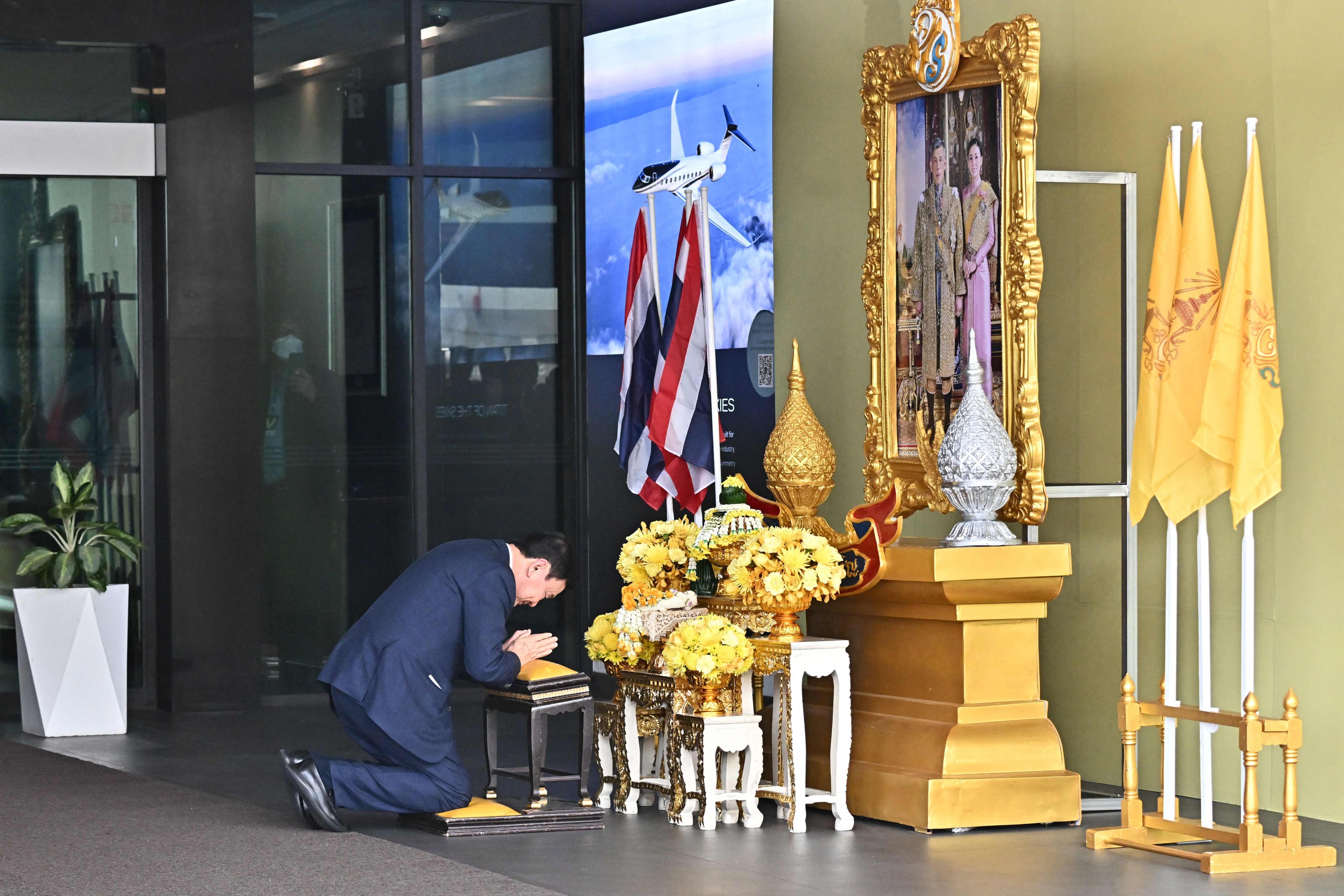 Thaksin Shinawatra bows in homage to the king’s portrait after landing at Bangkok’s Don Mueang airport on August 22. Photo: AFP 