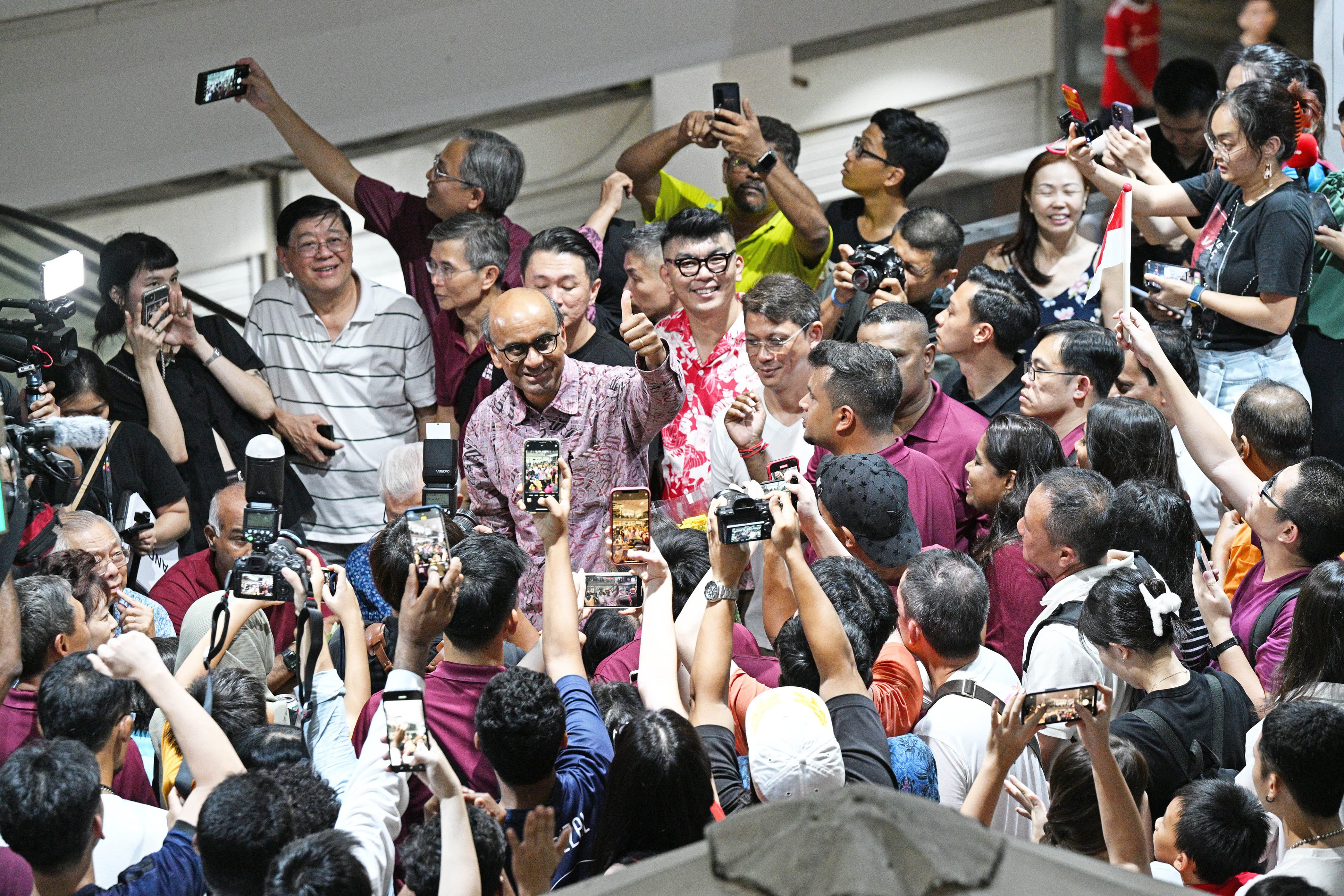 Tharman Shanmugaratnam (centre) gives a thumbs-up to his supporters while waiting for the results of the presidential election in Singapore on Friday. Tharman eventually won with 70.4 per cent of the vote to be elected as Singapore’s ninth president. Photo: Xinhua