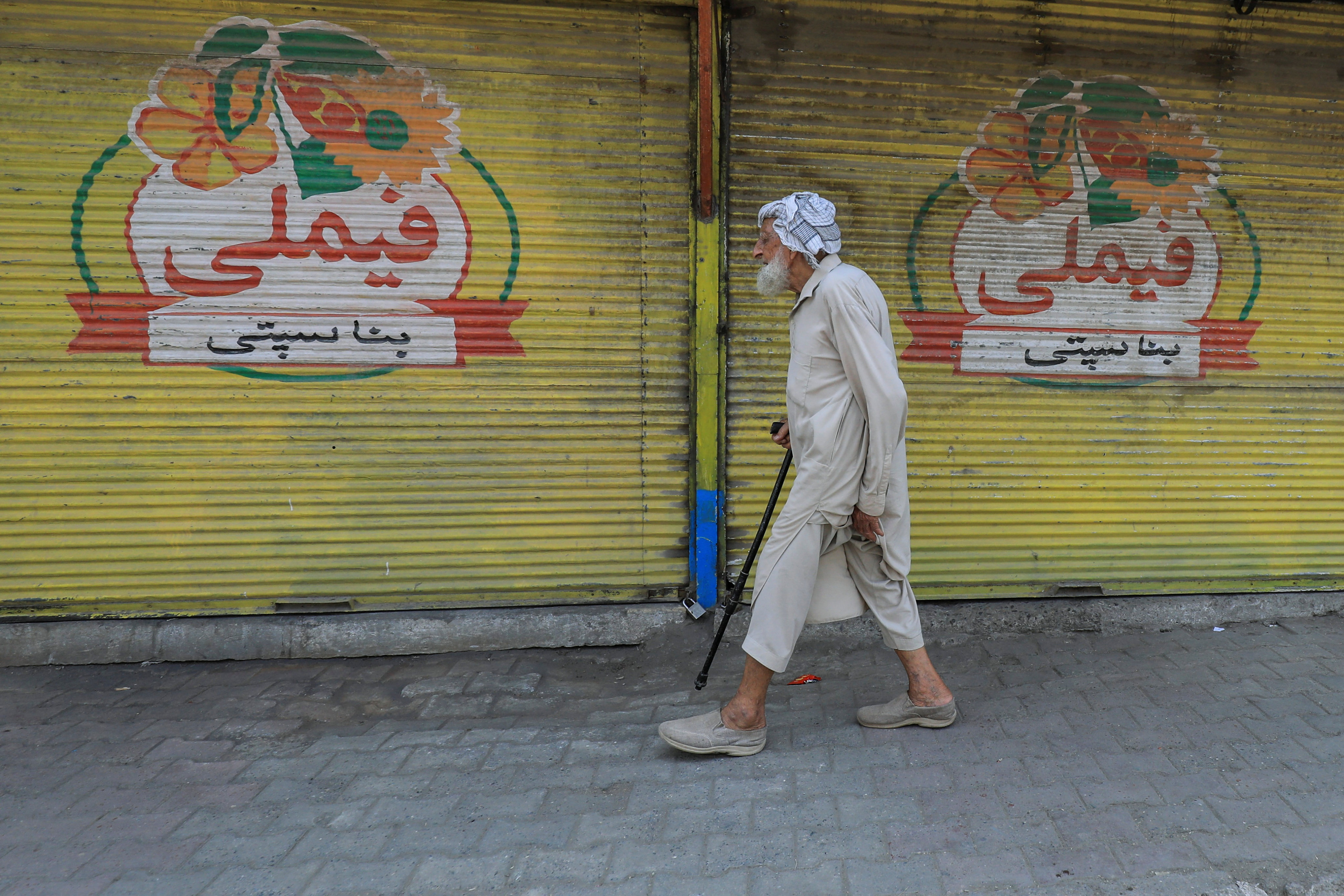 A man walks past closed shops during a strike call by traders in Pakistan. Photo: Reuters