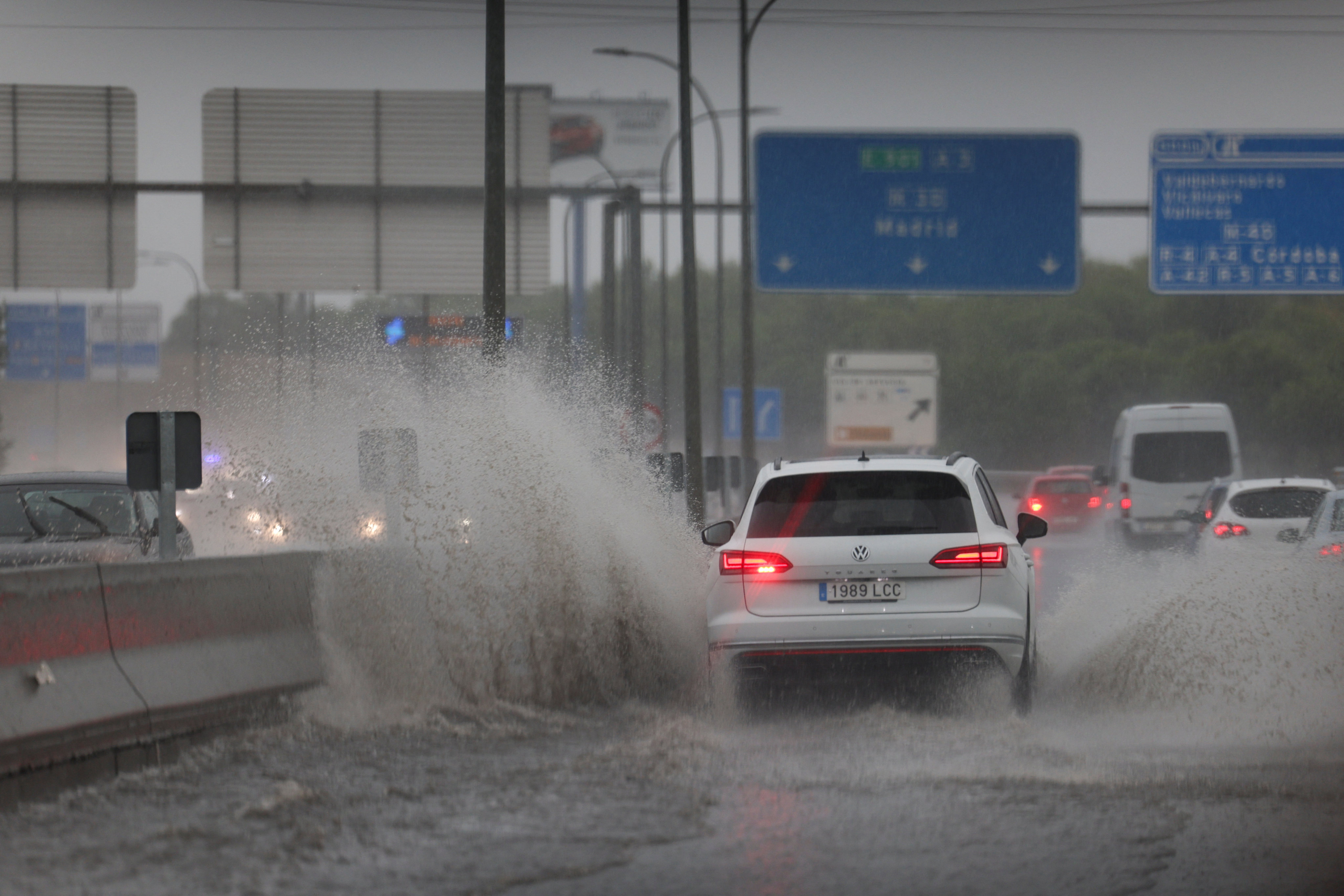 Cars pass through a large puddle of water caused by heavy rain following a red alert for severe storms, in Madrid, Spain on Sunday. Photo: Reuters 