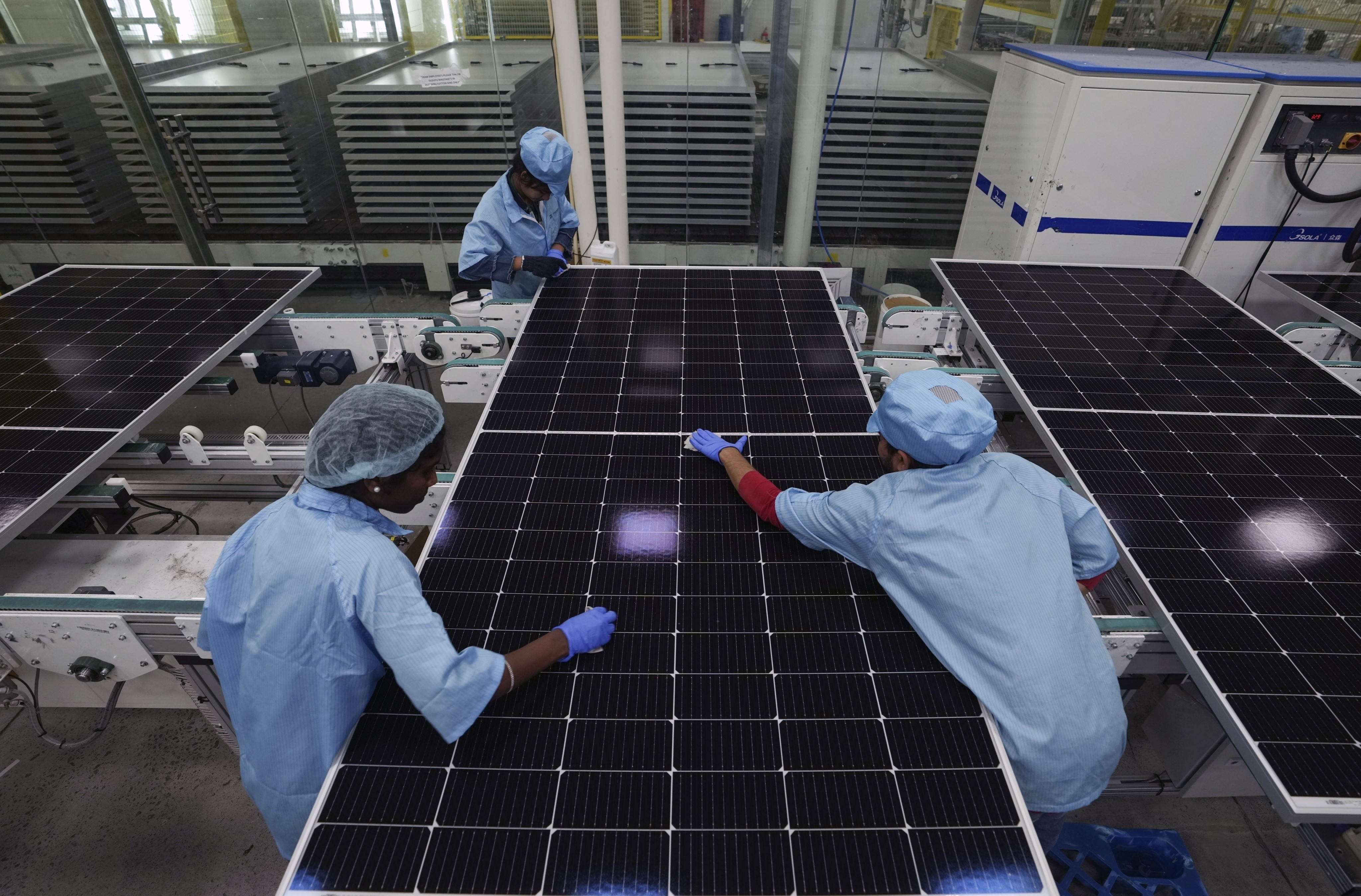 Machine operators clean solar panels at Premier Energies Solar on the outskirts of Hyderabad, India, on January 25. The recent trend of countries and firms trying to diversify their supply chains has been music to the ears of India, which has set itself ambitious targets for increasing manufacturing’s share of the country’s GDP. Photo: AP