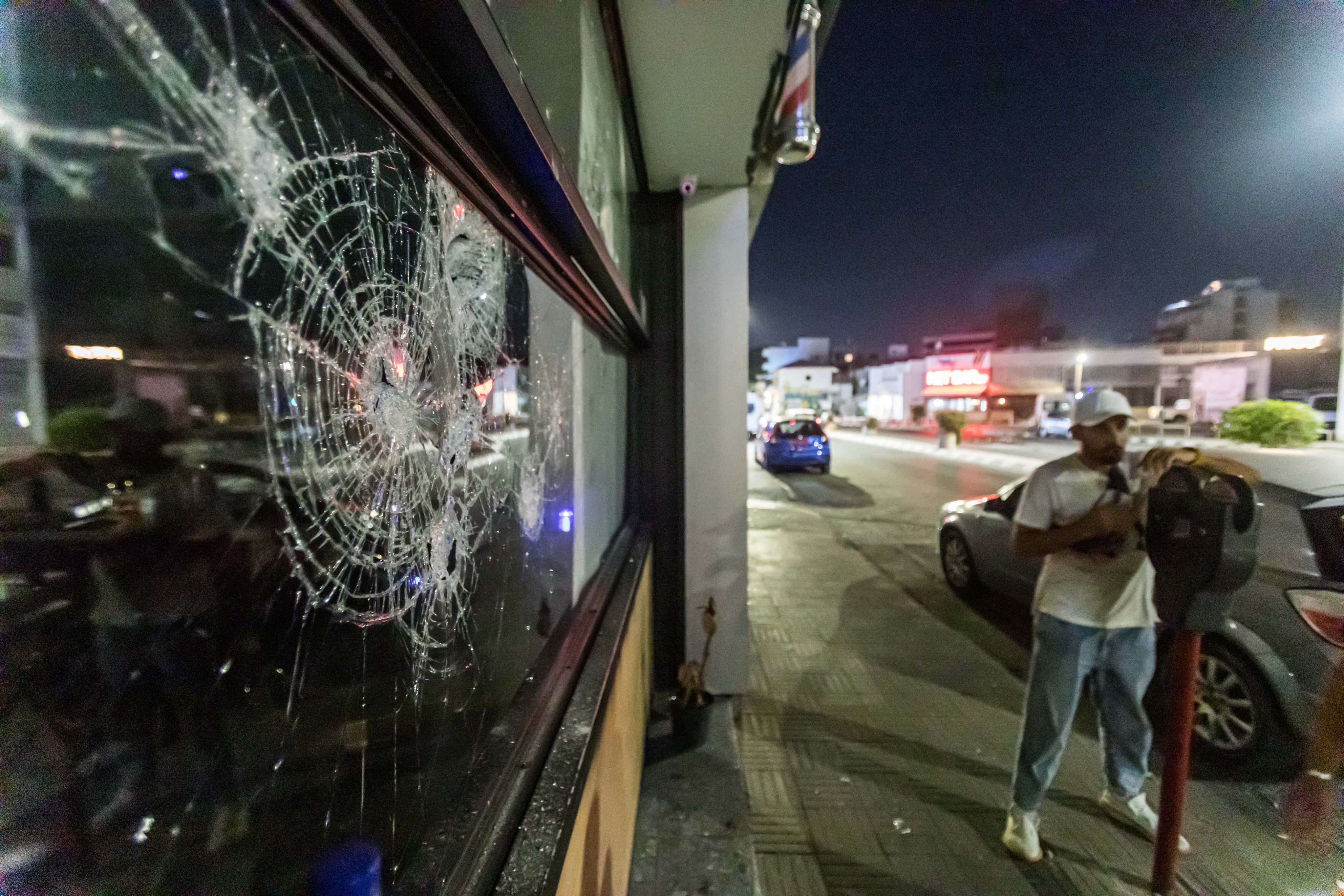 A shattered shop window after protesters attacked a hair salon belonging to a migrant in Limassol, Cyprus. Photo: Zuma Press Wire / dpa