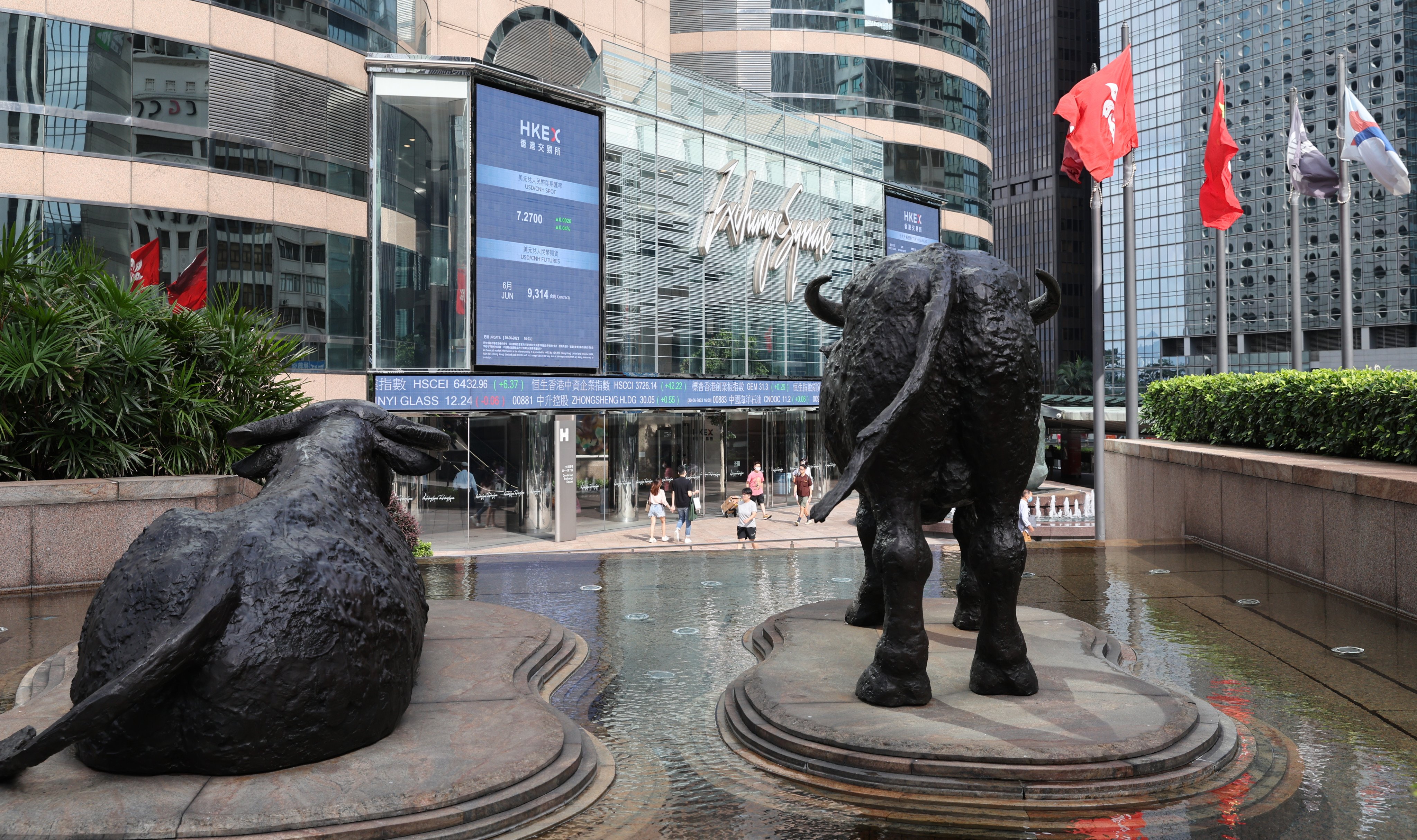 Statues of bulls face an electronic billboard displaying the Hang Seng Index and stock prices outside the Exchange Square in Central on June 30.  Photo: Yik Yeung-man