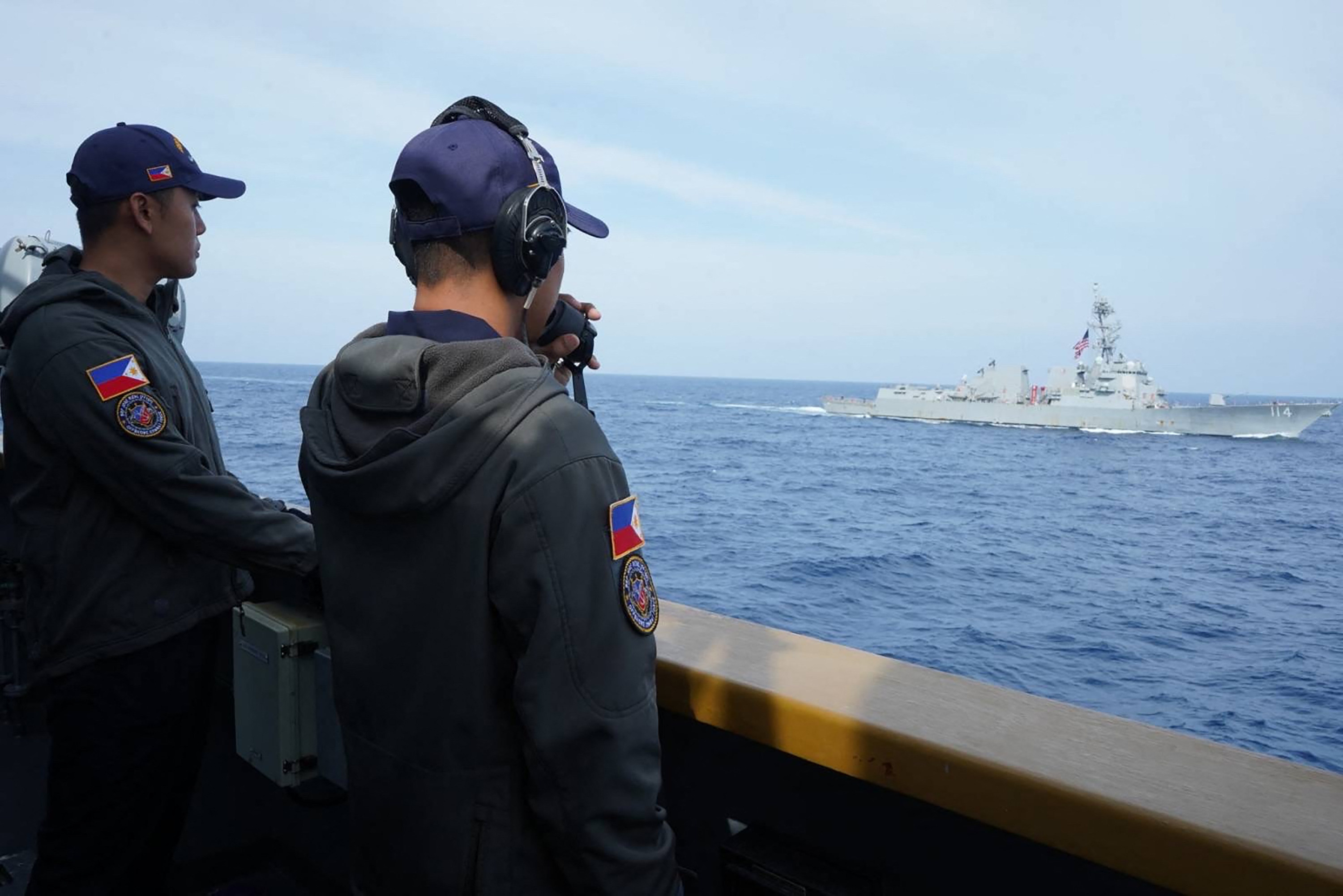 Philippine sailors aboard the frigate BRP Jose Rizal look on as the USS Ralph Johnson guided missile destroyer sails in the South China Sea on Monday. Photo: AFP/Armed Forces of the Philippines