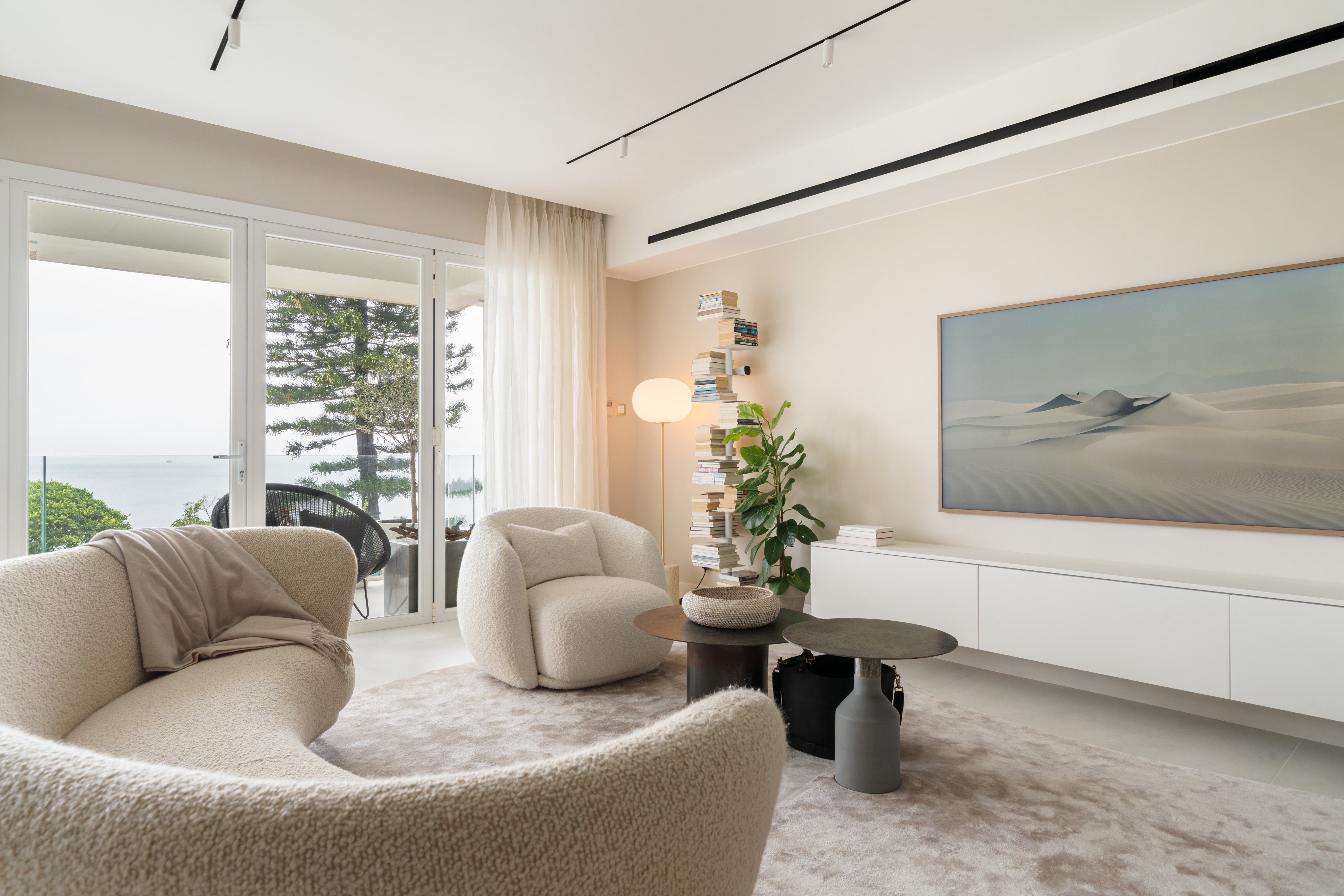 The living room of a two-storey duplex family apartment in Repulse Bay, Hong Kong, shows the muted colour palette that makes its sea views the focus. Photo: Dela Peri John David Adecer
