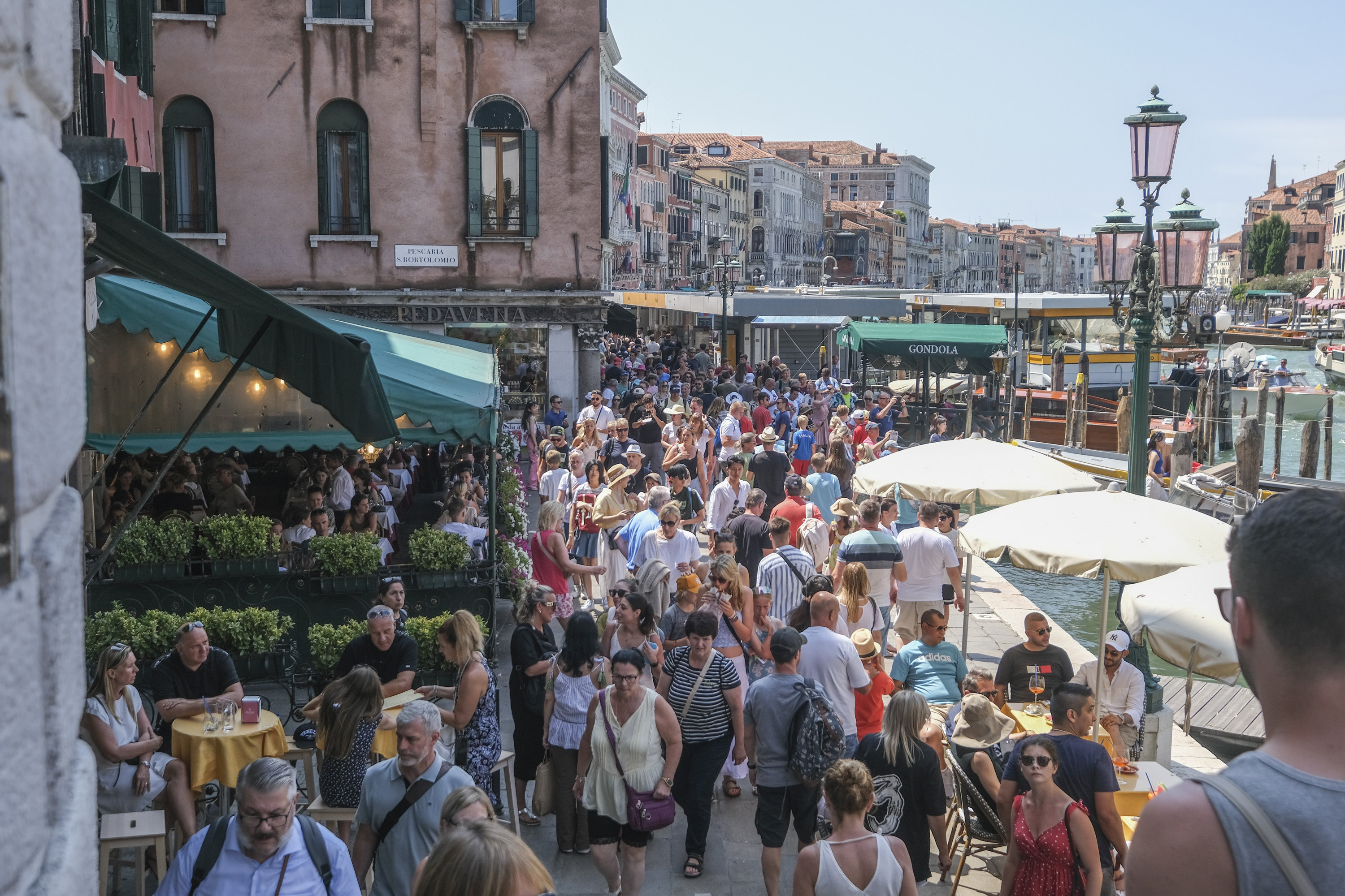 Tourists crowd the area near the Rialto Bridge in Venice on a day in August 2023. The city council has approved guidelines for trials of a new entry fee in 2024 for day trippers visiting the city. Photo: Getty Images