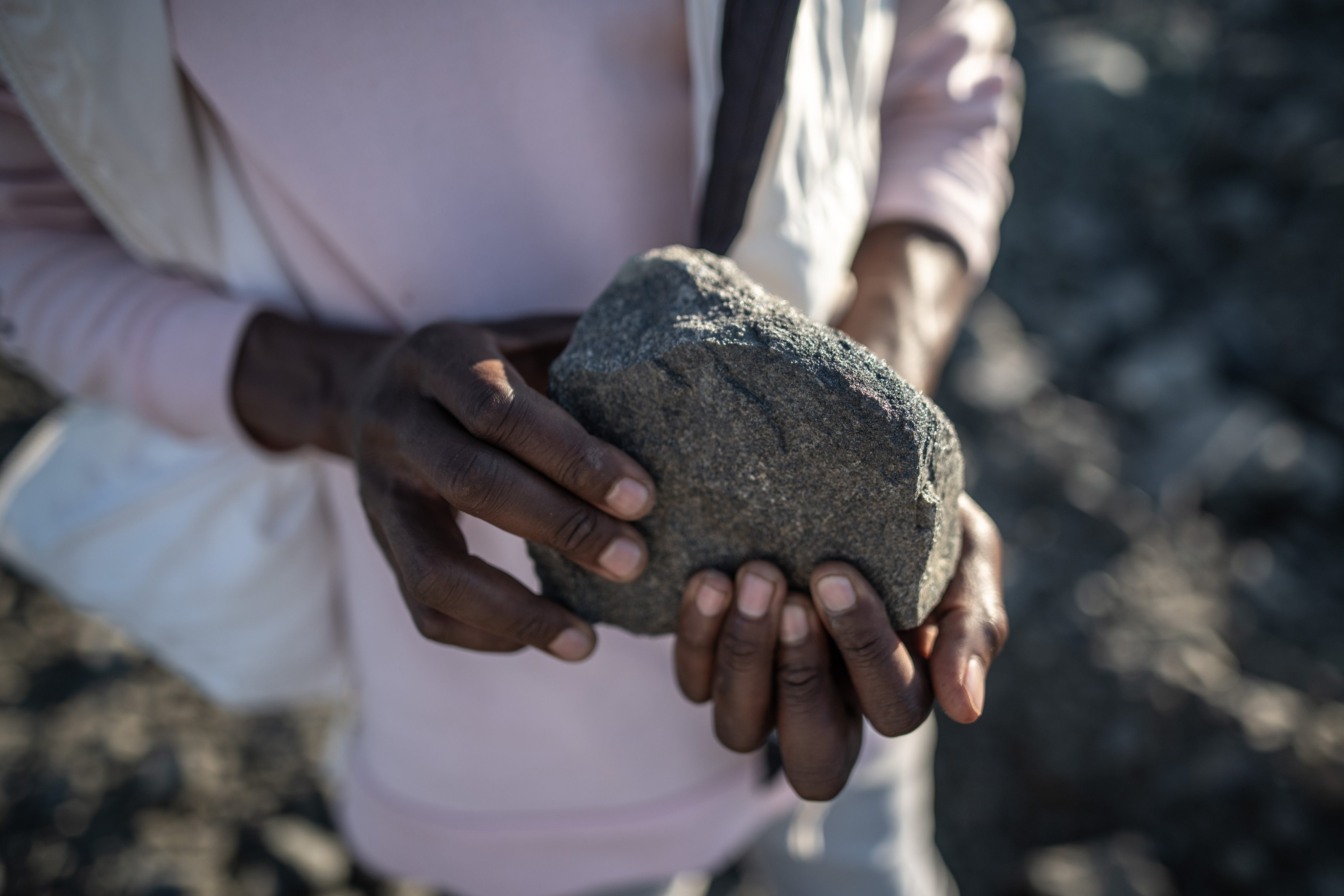 A man holds a piece of chrome-rich rock at an illegal mine in Witrandjie, South Africa. Chinese demand for chromium to make stainless steel is blighting rural communities and scarring the land. Photo: Bloomberg