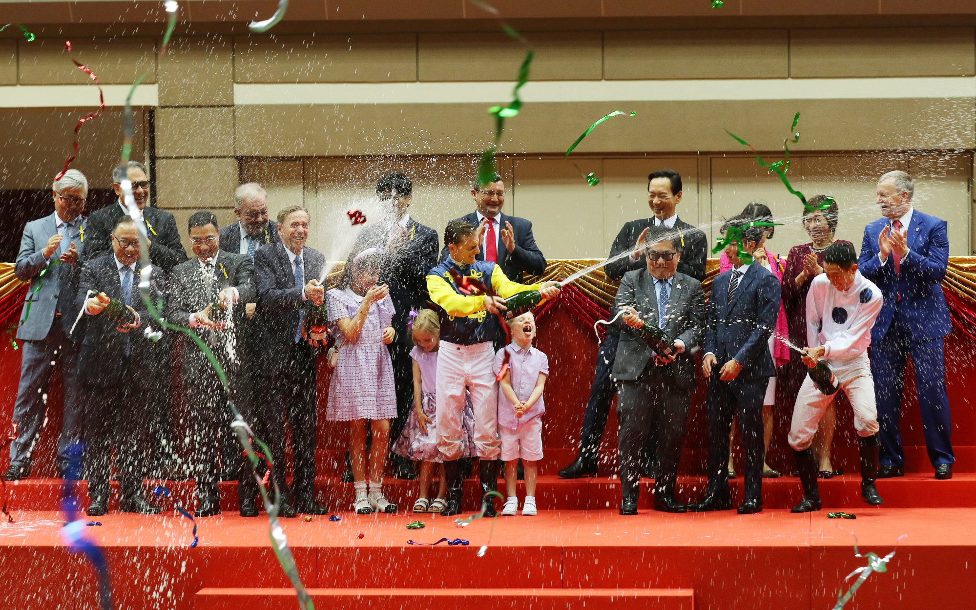 Jockey Zac Purton (centre) sprays champagne at last season’s finale.