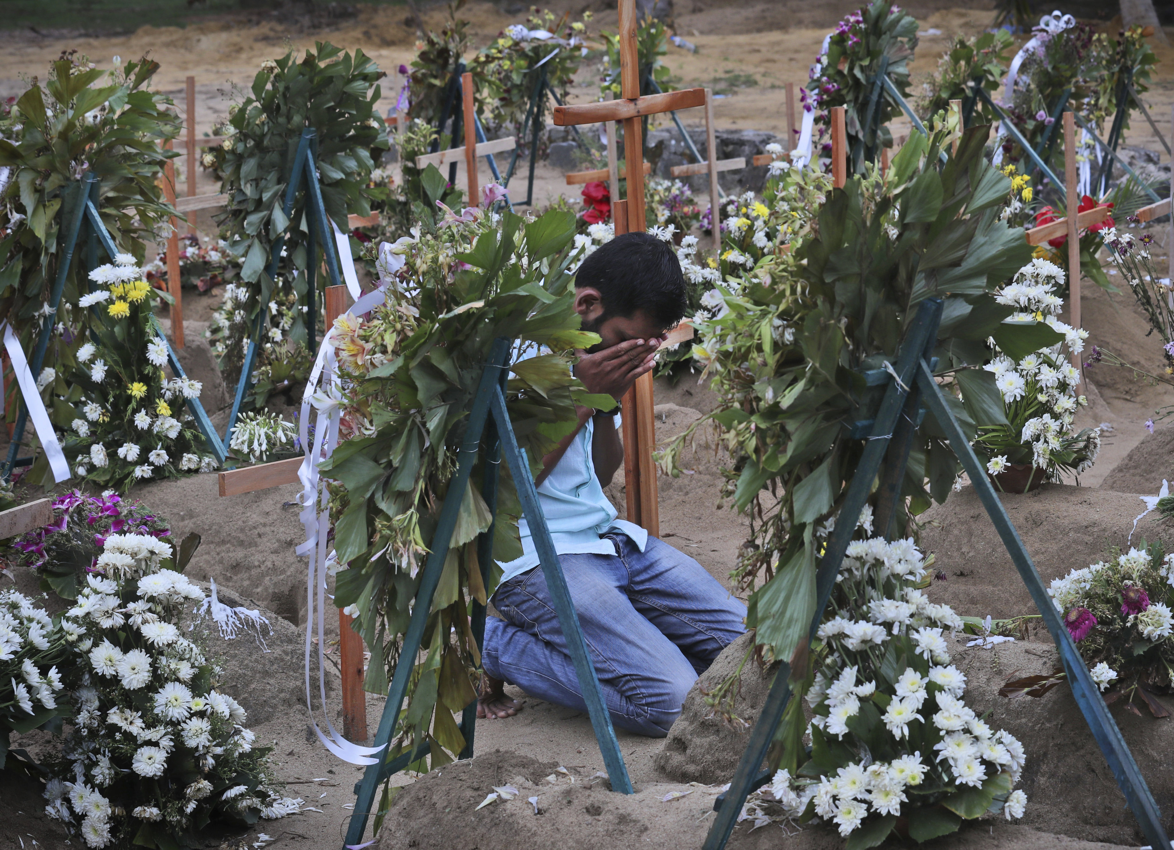 A relative of a victim of the 2019 Easter Sunday bomb blasts in Sri Lanka pays tribute at a burial site. File photo: AP