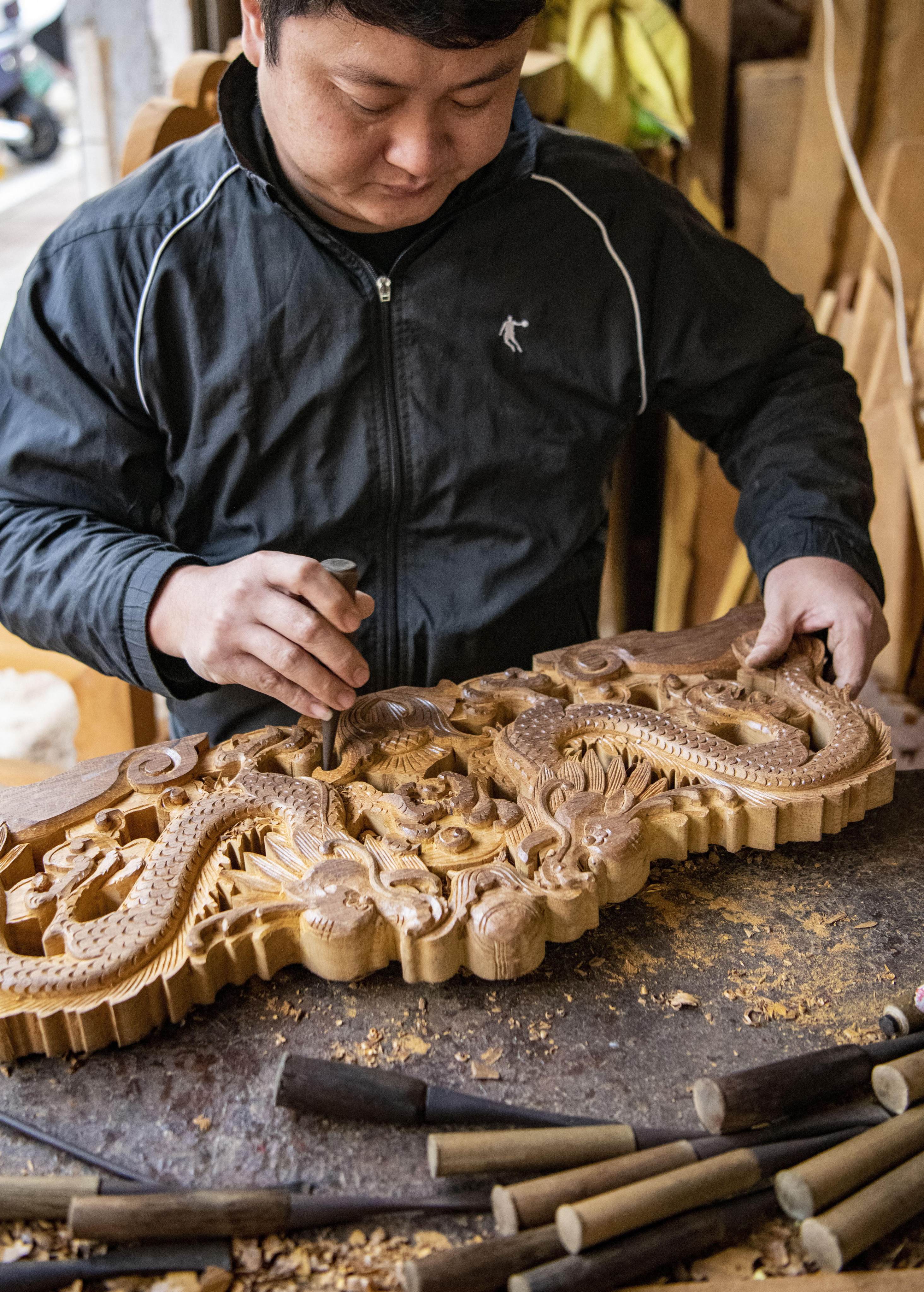 A worker making classical wood-carved furniture in a factory in Qionghai, Hainan, southern China. A revival in domestic demand for traditional carved furniture has helped revive old skill sets that disappeared when copies of foreign furniture styles became popular. Photo: AFP