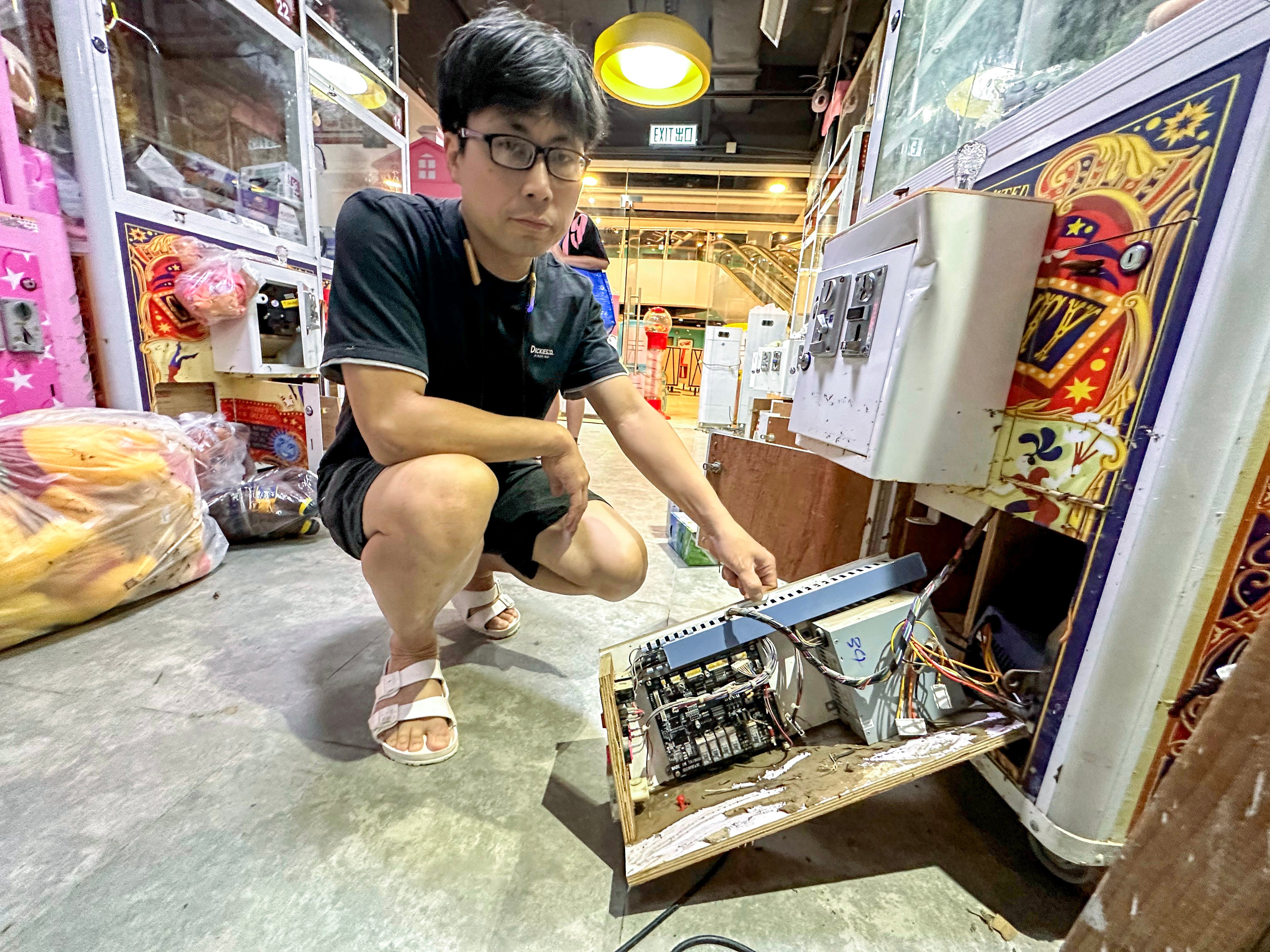 Choi Kai-yip, the owner of Yatta, a claw machine shop in Chai Wan, shows electronics wrecked by last week’s floodwaters. Photo: Oscar Liu