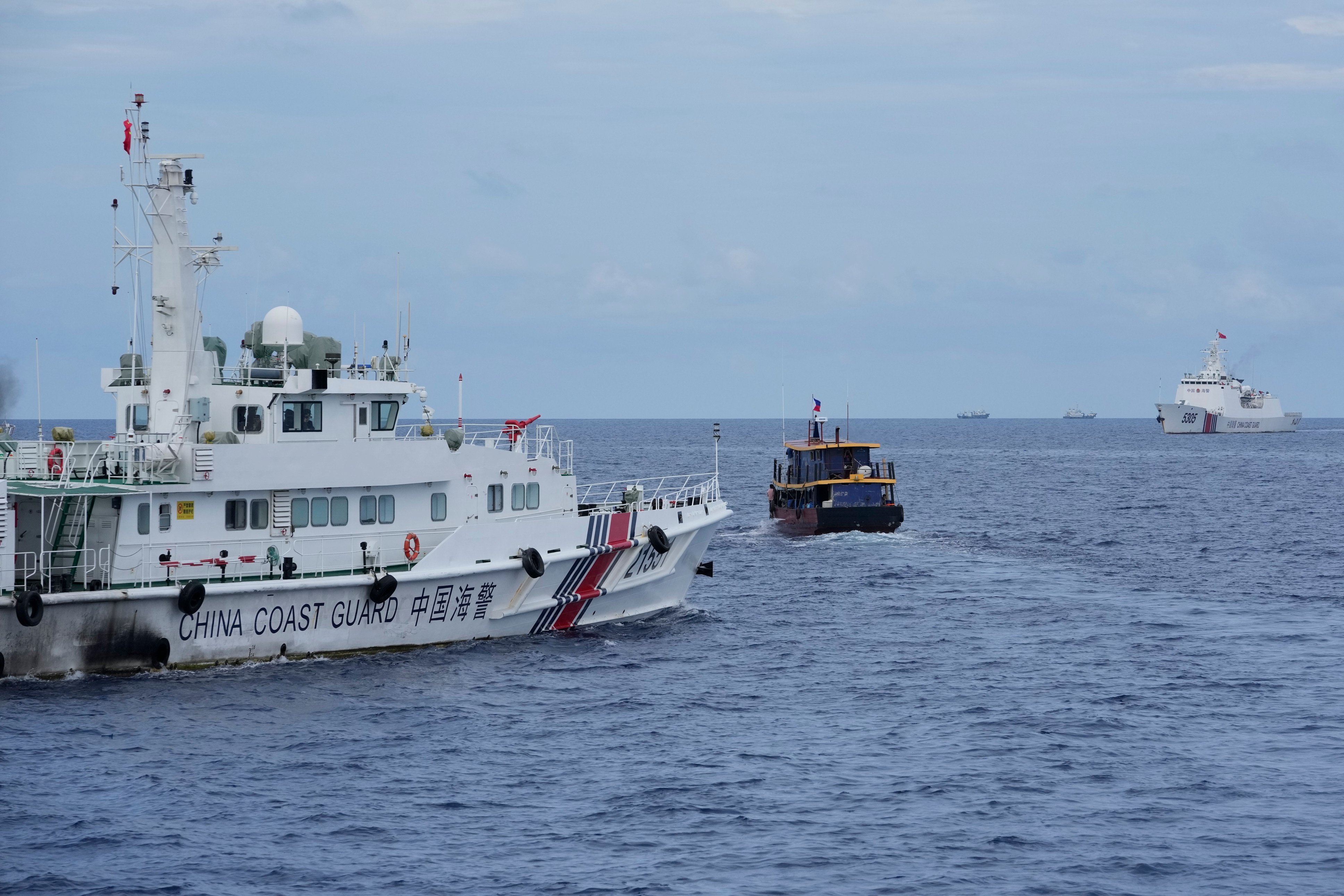 A Philippine supply boat avoids one of the Chinese coast guard ships that tried to block its way off Second Thomas Shoal. Photo: AP
