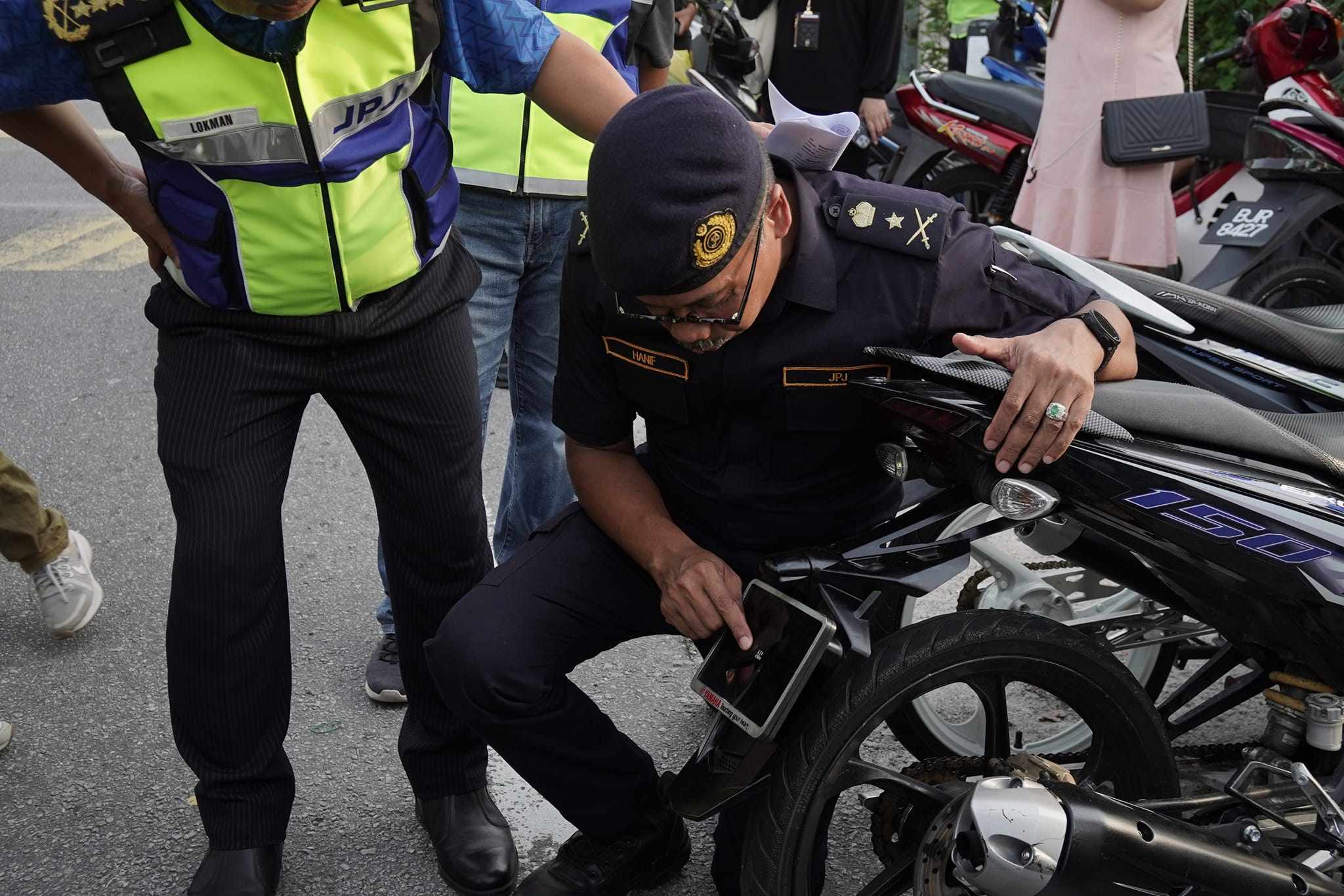 The motorcycle licence plate discovered by Malaysian police was smaller than one of the officer’s fingernails, and its numbers could barely be seen. Photo: Facebook/Jabatan Pengangkutan Jalan Malaysia