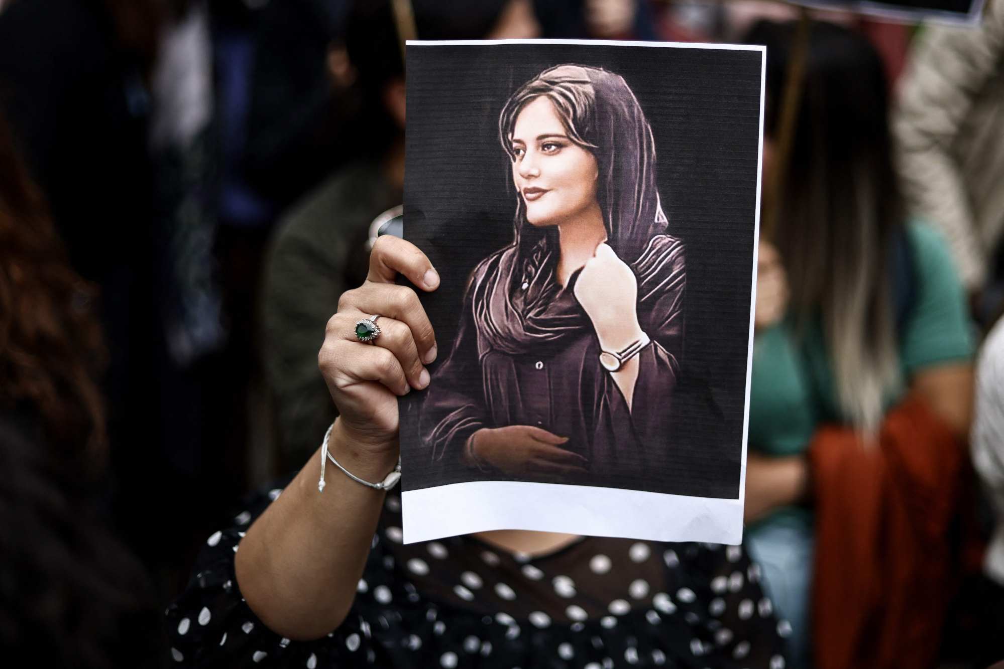A protester holds a portrait of Mahsa Amini in front of the Iranian embassy in Brussels. Photo: AFP