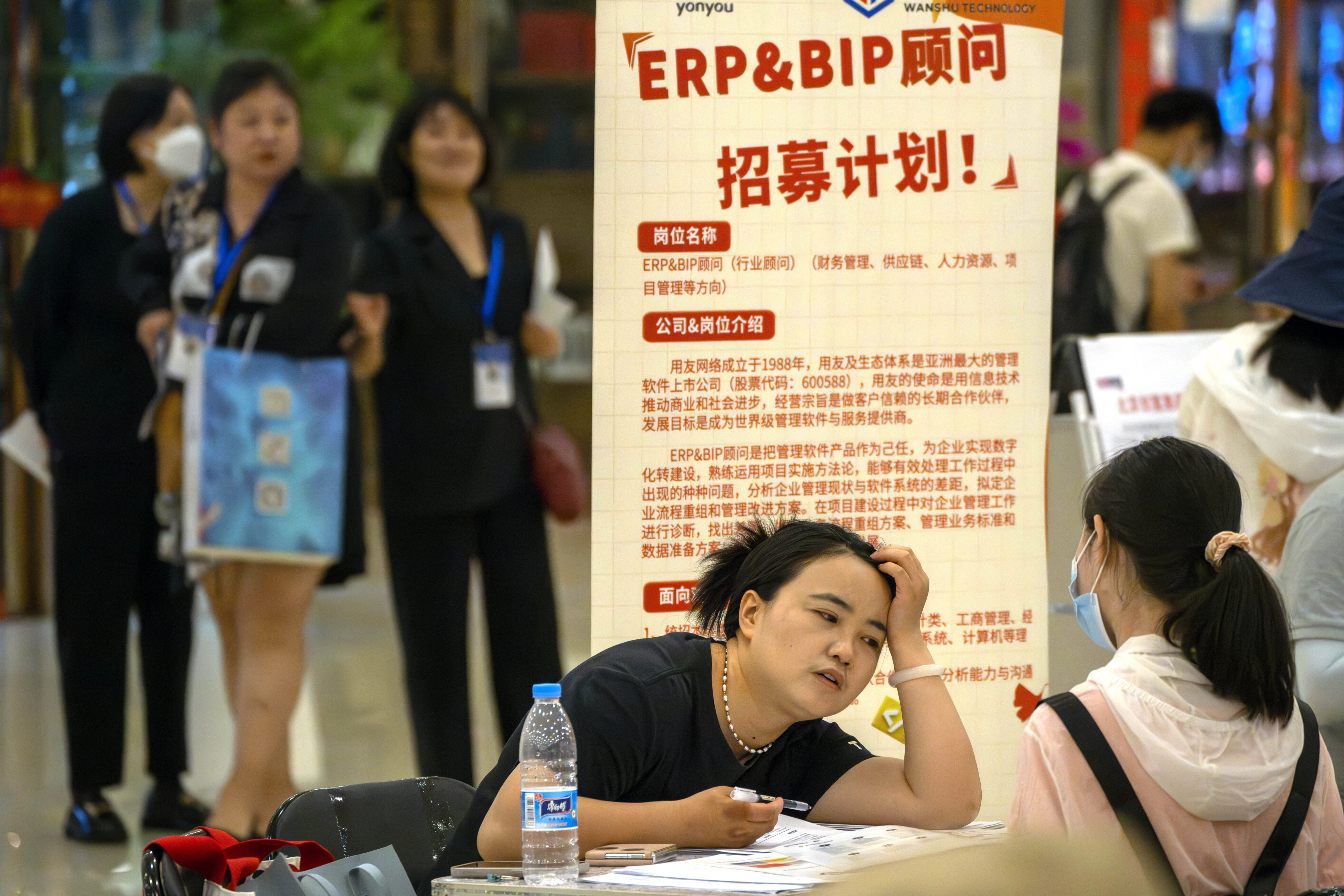 A recruiter talks to an applicant at a booth at a job fair at a shopping centre in Beijing on June 9. More than one in five young Chinese are out of work, one of several pressing concerns that are weighing on China’s economy and threatening to spill over to hurt other emerging markets. Photo: AP