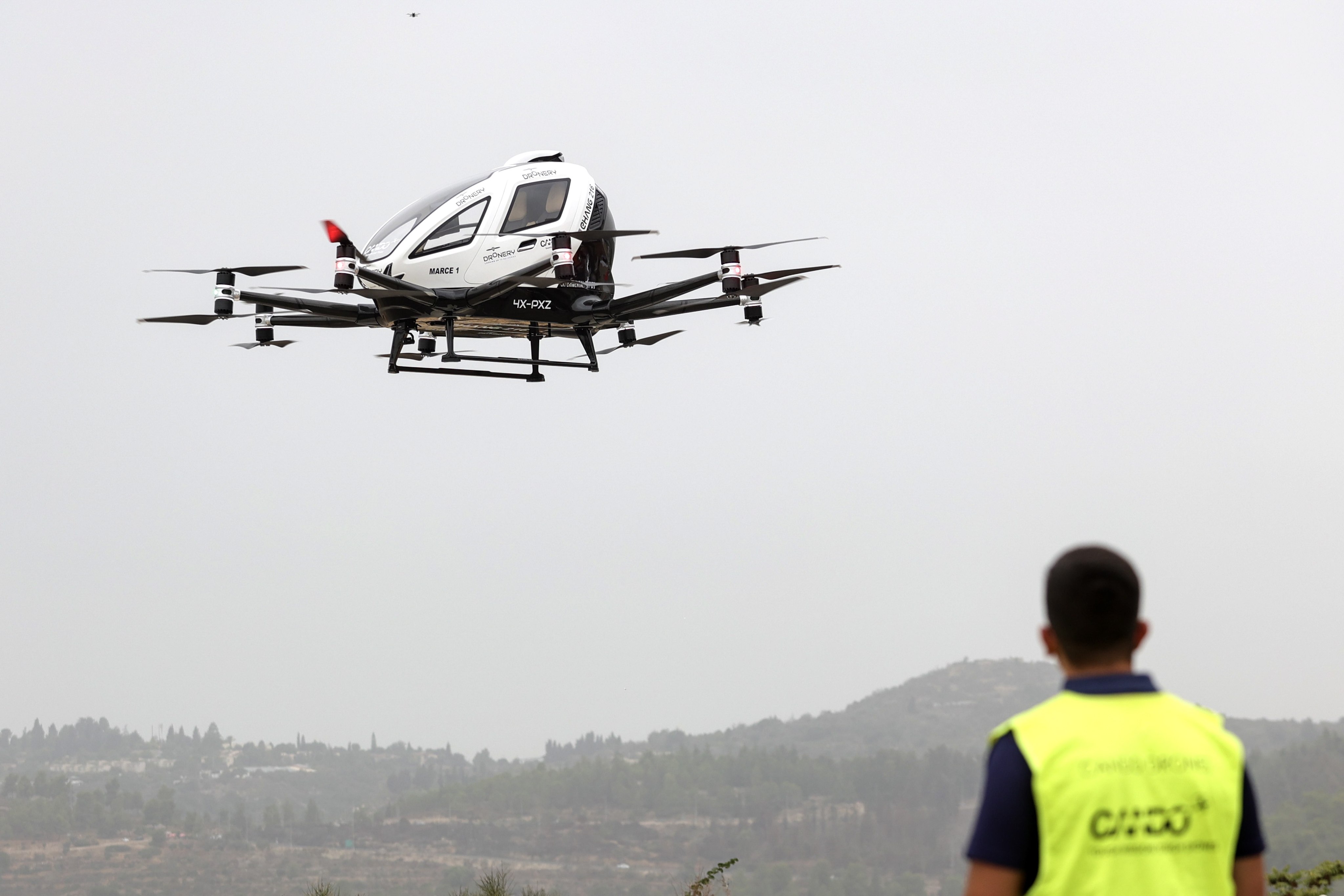 An Israeli worker watches a drone taxi during a test flight in Jerusalem on Wednesday. Photo: EPA-EFE