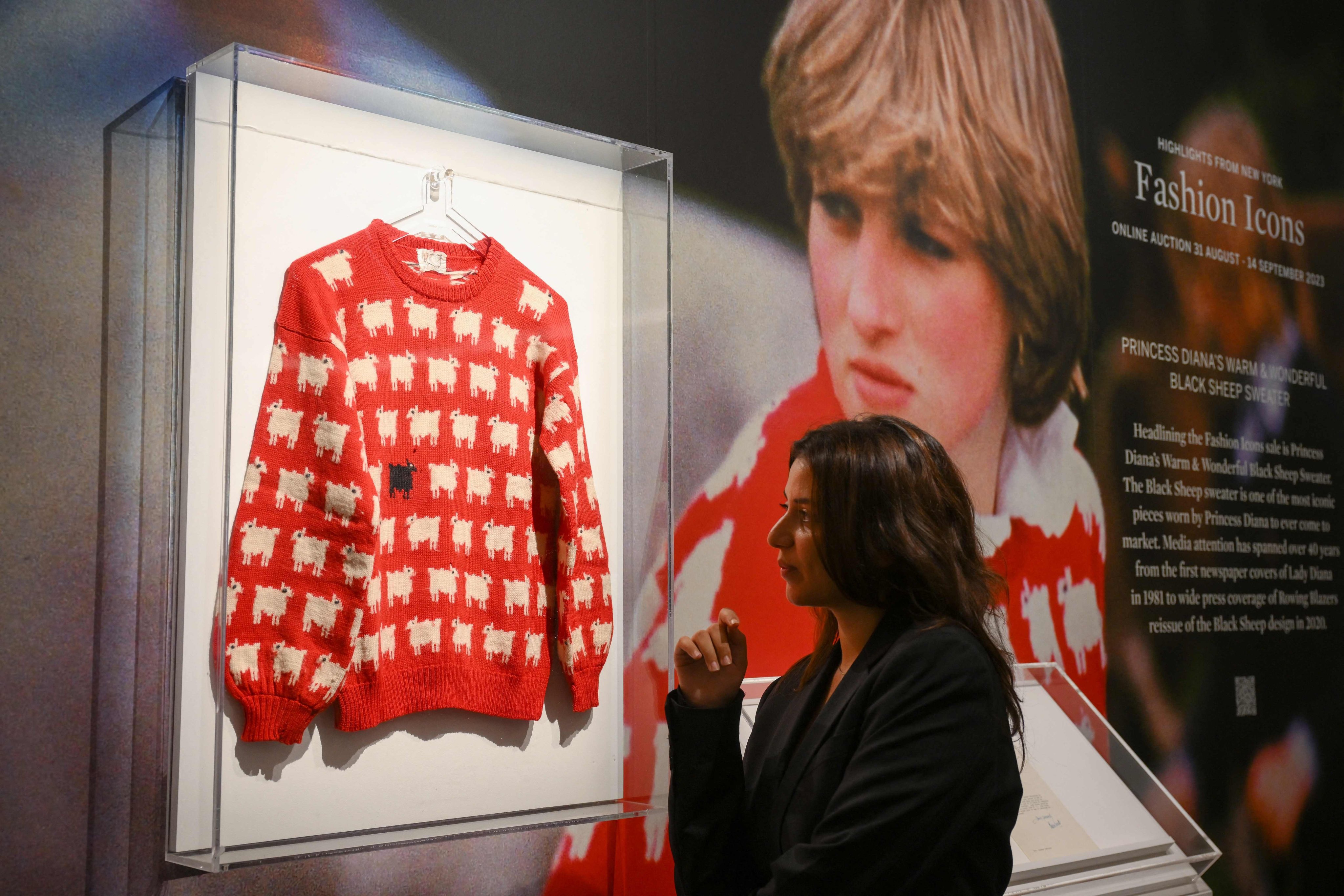 A staff member poses with Princess Diana’s “Black Sheep” jumper at Sotheby’s auction house in London in July. Photo: AFP