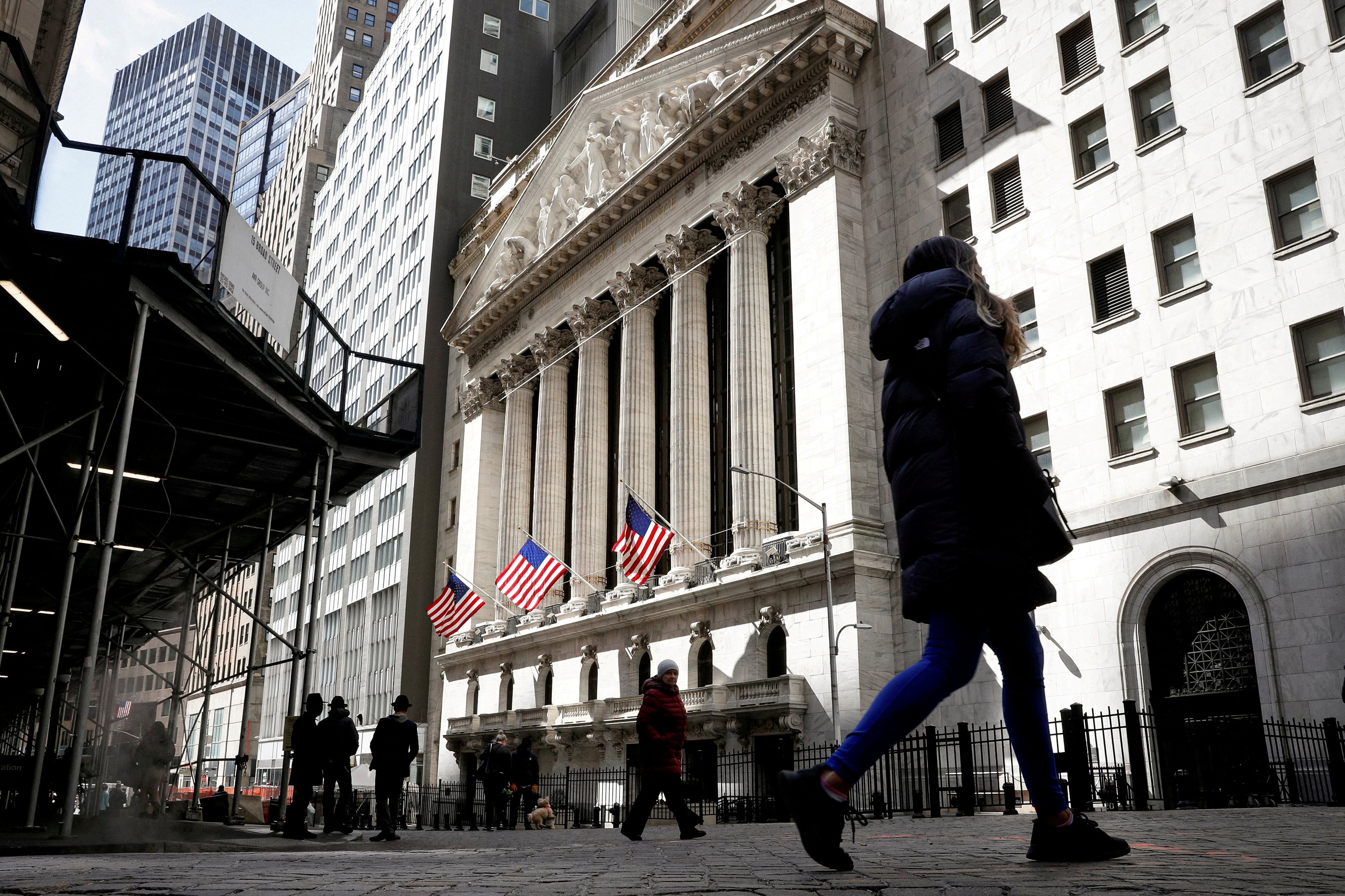 People are seen on Wall Street outside the New York Stock Exchange in New York City in March 2021. The Financial Stability Board has warned of “further challenges and shocks” in coming months as high interest rates undermine economic recovery and threaten key sectors, including real estate. Photo: Reuters 