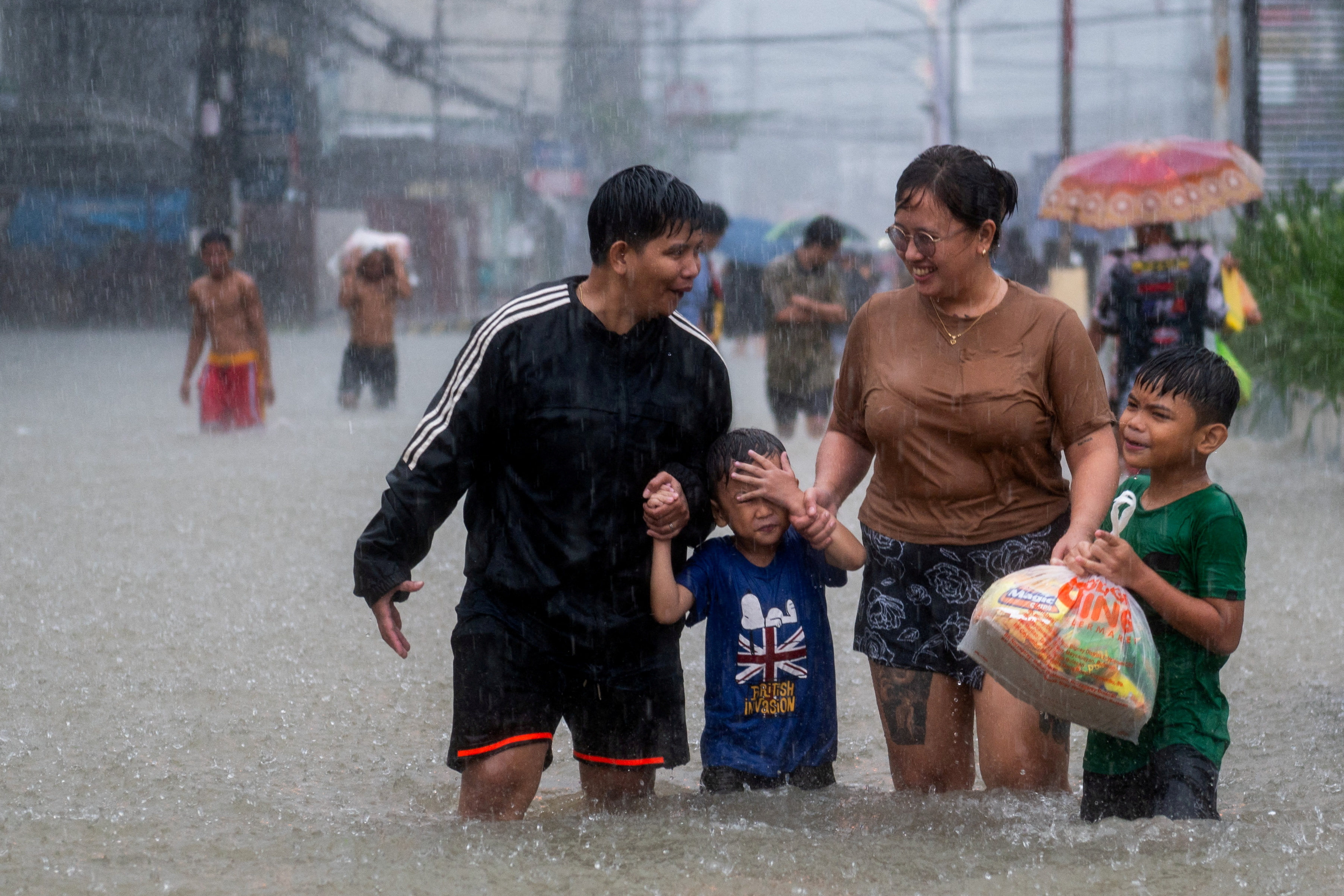 People wade through a flooded road, due to monsoon rains and the recent typhoon Doksuri, in Balagtas, Bulacan province, Philippines, on July 29. Photo: Reuters