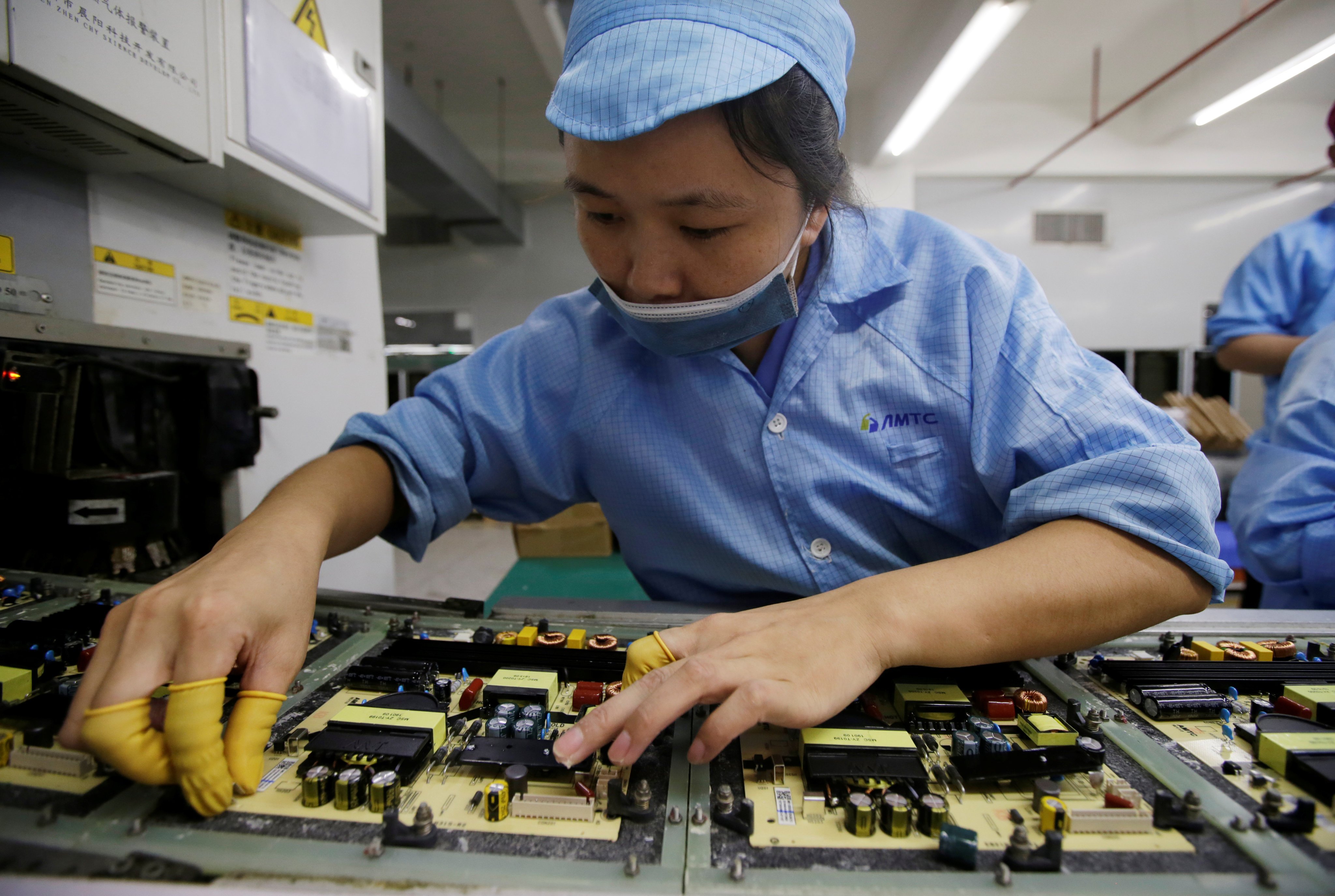 An employee works on the production line of a television factory in Shenzhen. Photo: Reuters