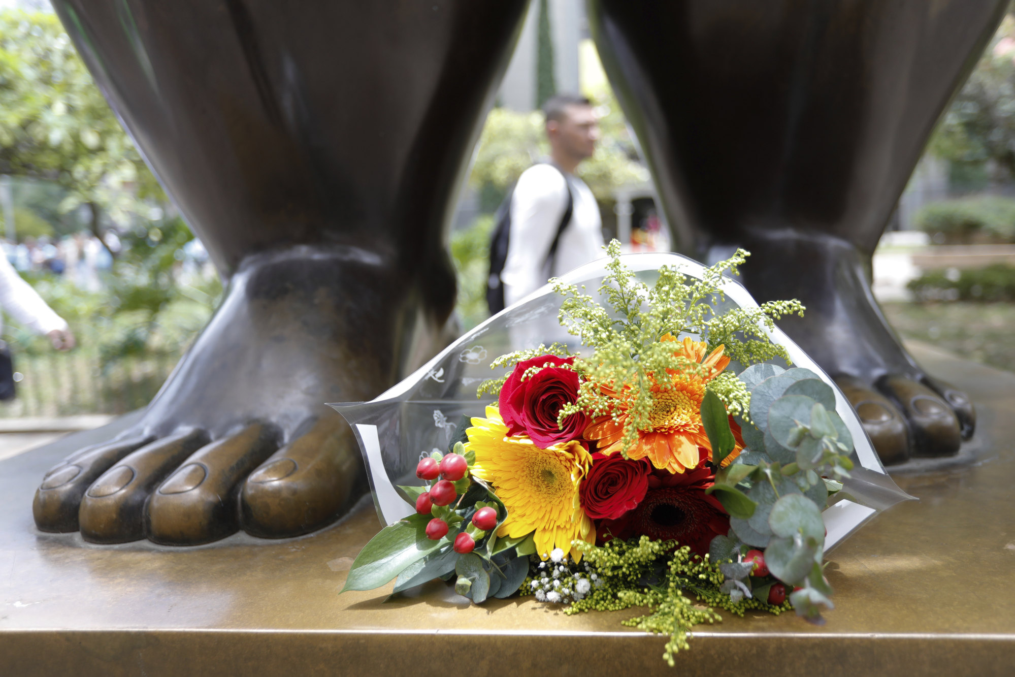Flowers sit at the feet of a sculpture by Colombian artist Fernando Botero in Medellin, Colombia on Friday. Photo: AP