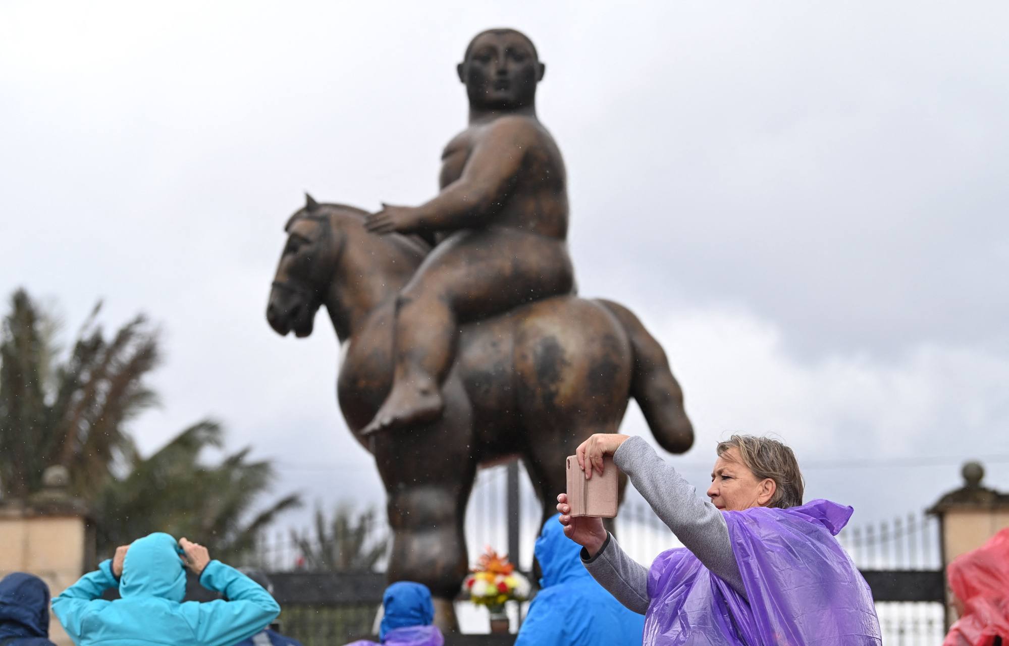 A tourist takes a picture in front of statue by Colombian artist Fernando Botero in Bogota on Friday. Photo: AFP