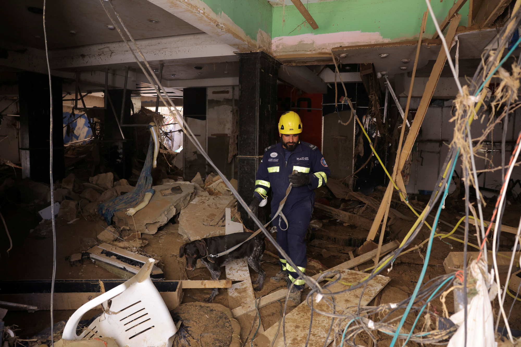 A United Arab Emirates search and rescue member employs a dog to search a destroyed building in Derna, Libya, on Saturday. Photo: Reuters