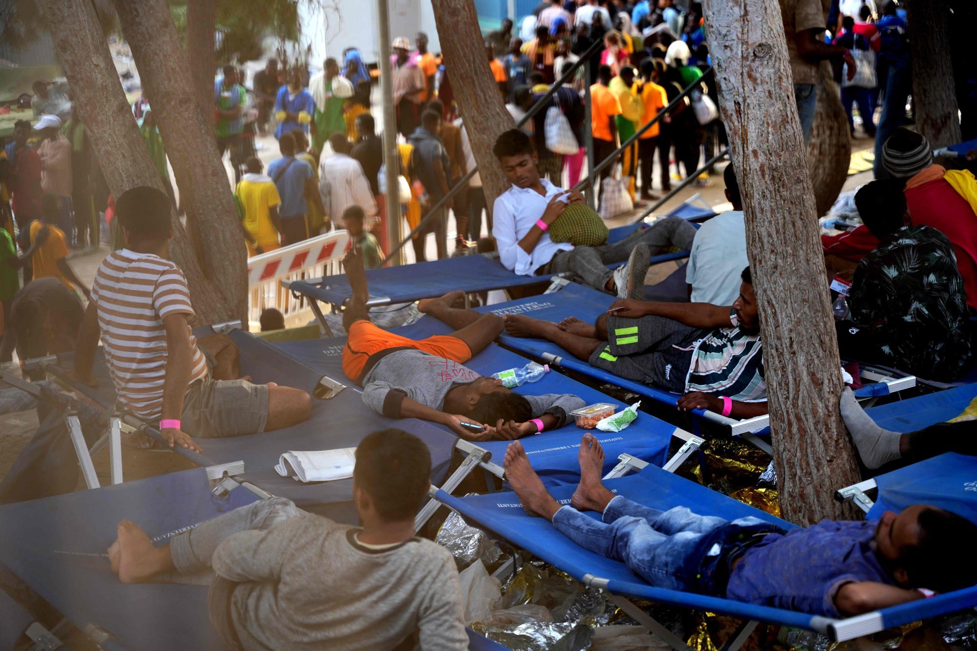 Migrants rest at a camp on the Italian island of Lampedusa on Saturday. Thousands were transferred to Sicily on Friday, but there were further arrivals by sea. Photo: AFP