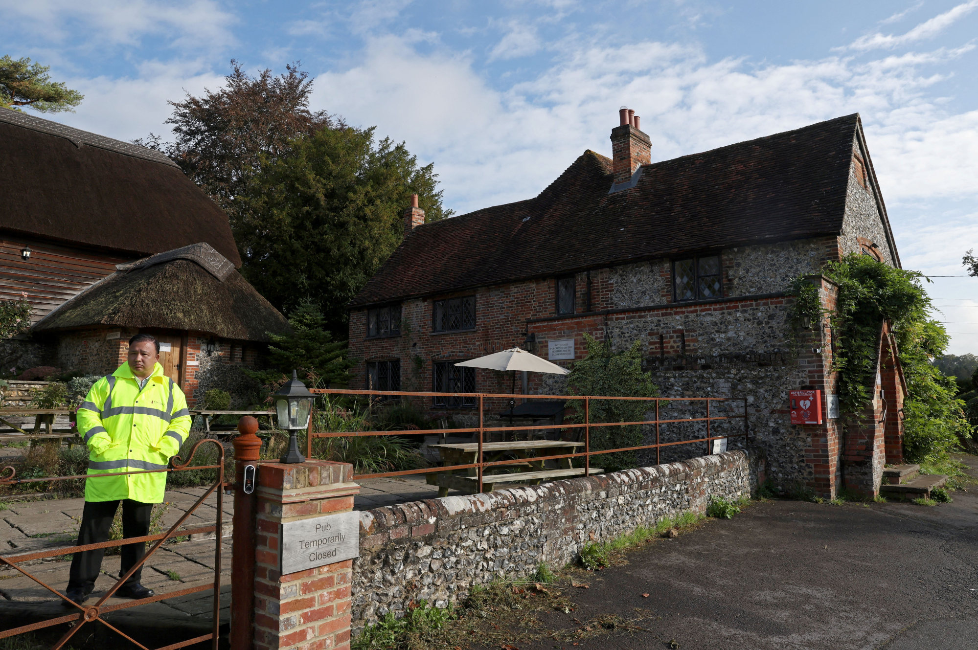 A security officer stands outside the Crown Inn pub owned by British comedian and actor Russell Brand’s company near Henley-on-Thames, Oxfordshire. Photo: Reuters