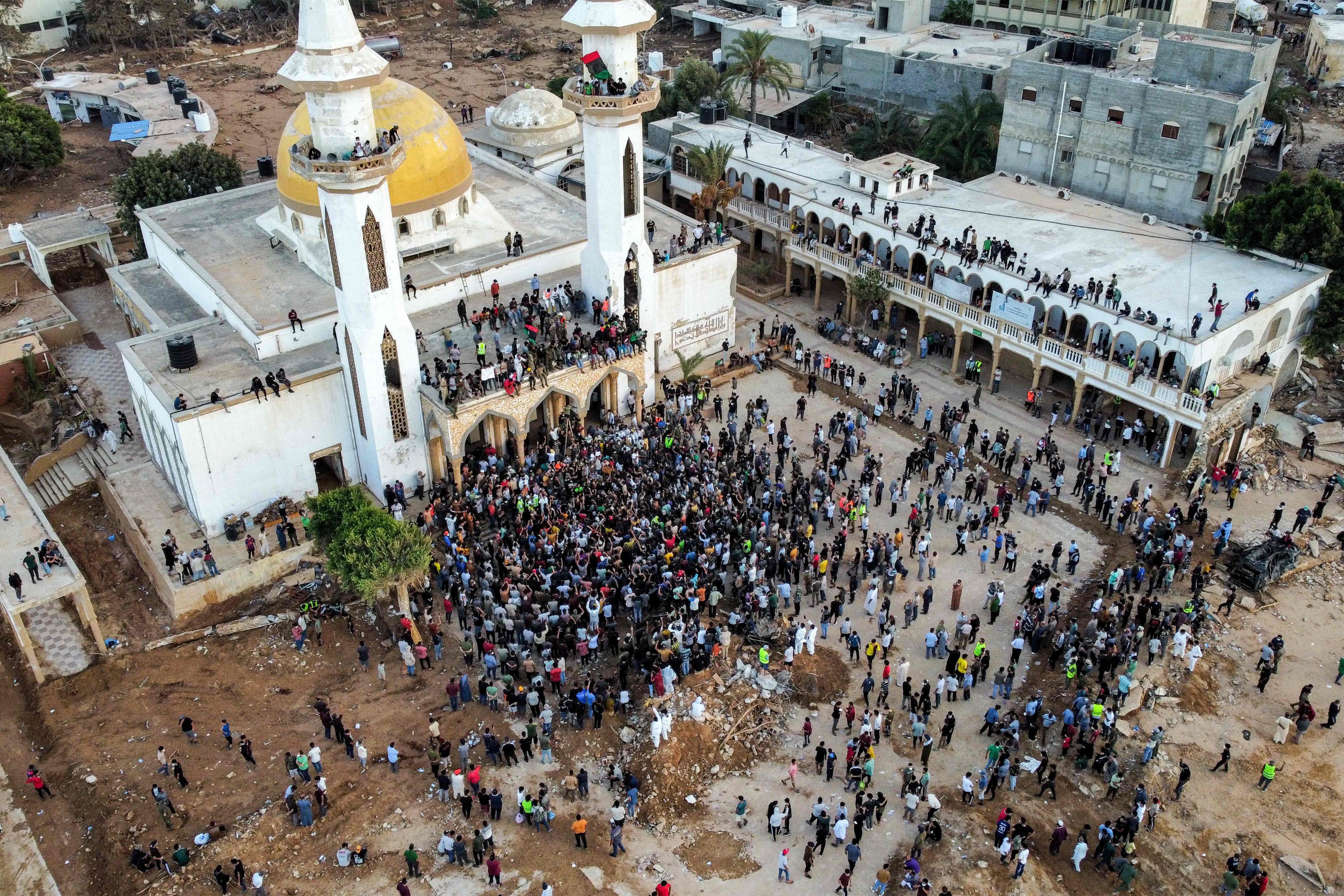 People gather outside a mosque in Libya’s city of Derna on Monday, to protest against the neglect of two dams which broke on September 10, leading to devastating floods. Photo: AFP