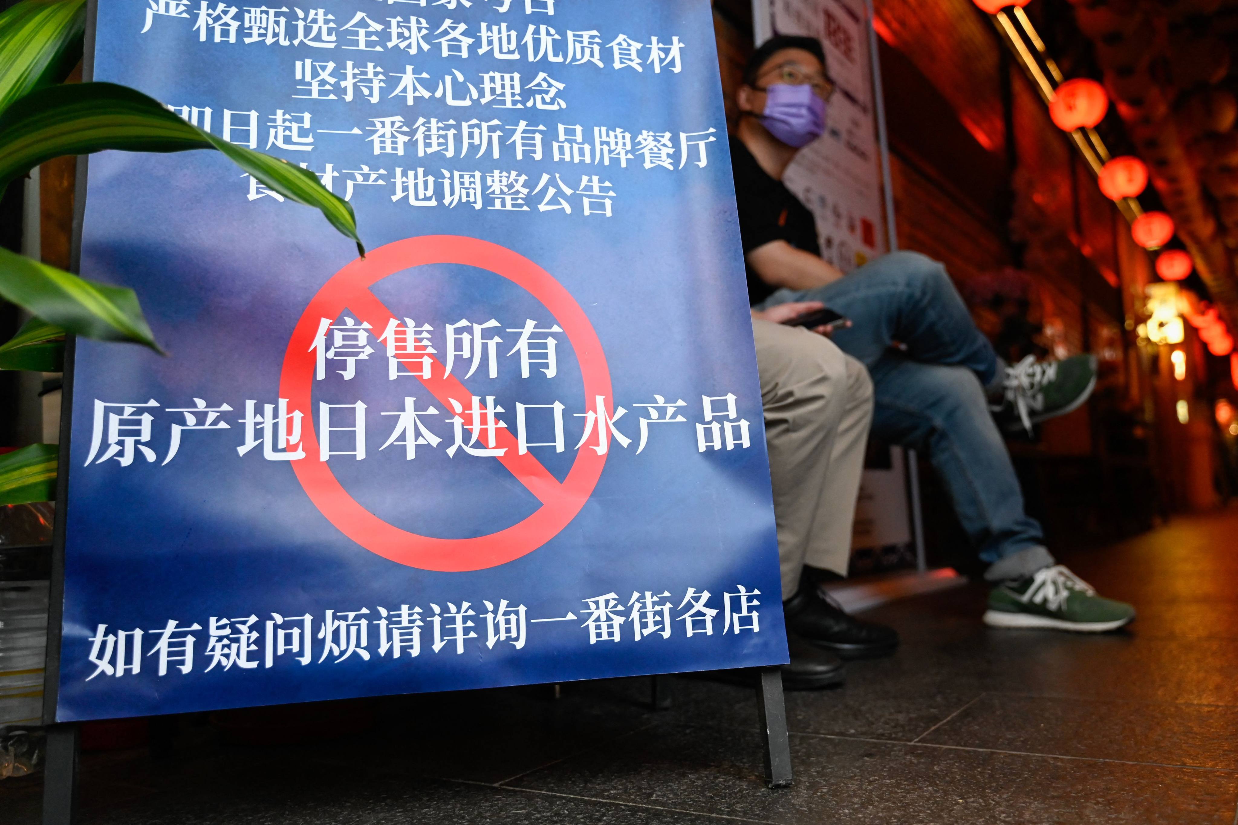 A sign is placed outside a Japanese restaurant in Beijing informing customers that it has suspended the sale of all seafood imported from Japan, on August 27. Photo: AFP