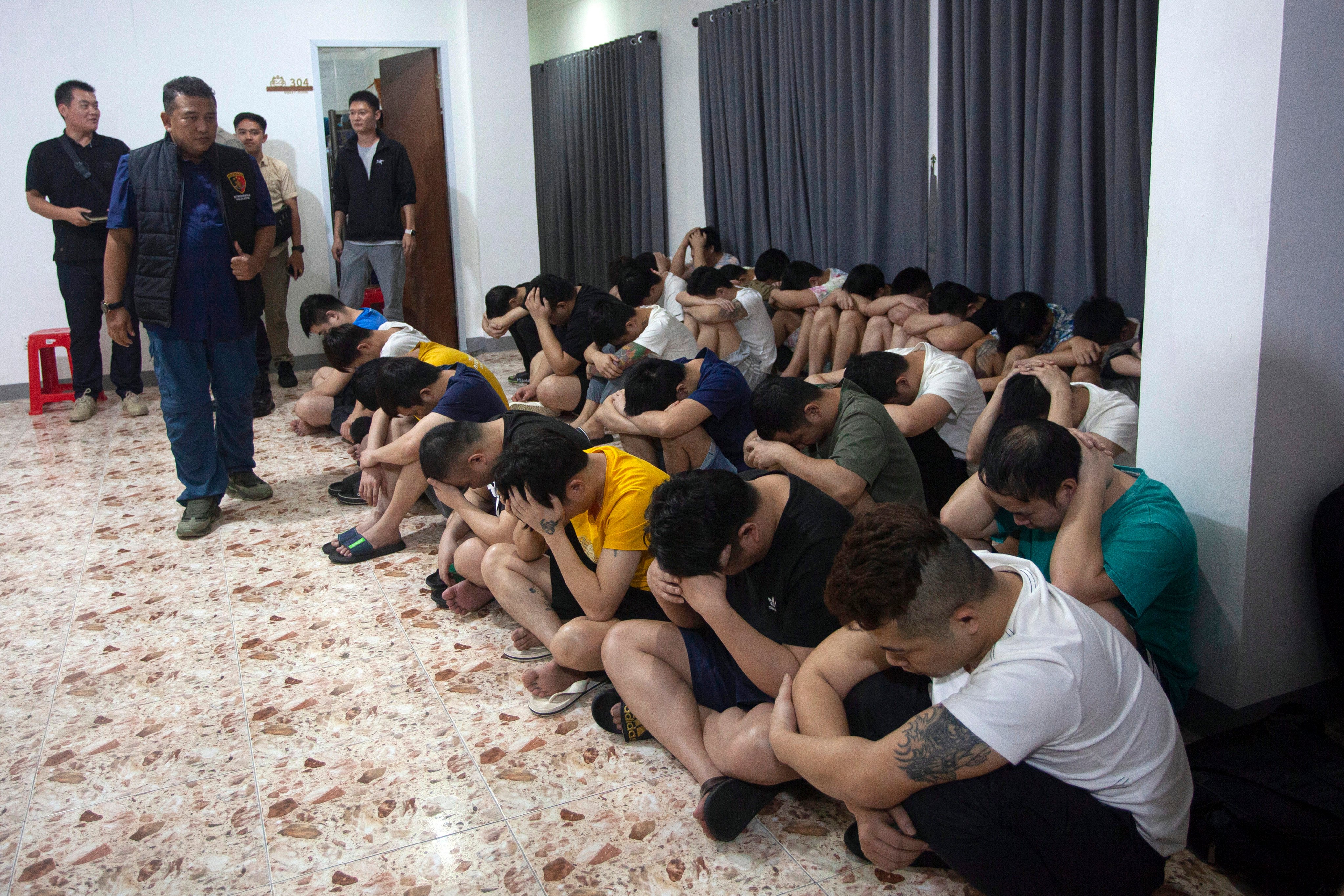 Chinese nationals are detained after a raid on a shophouse in Batam on August 29. Photo: AP