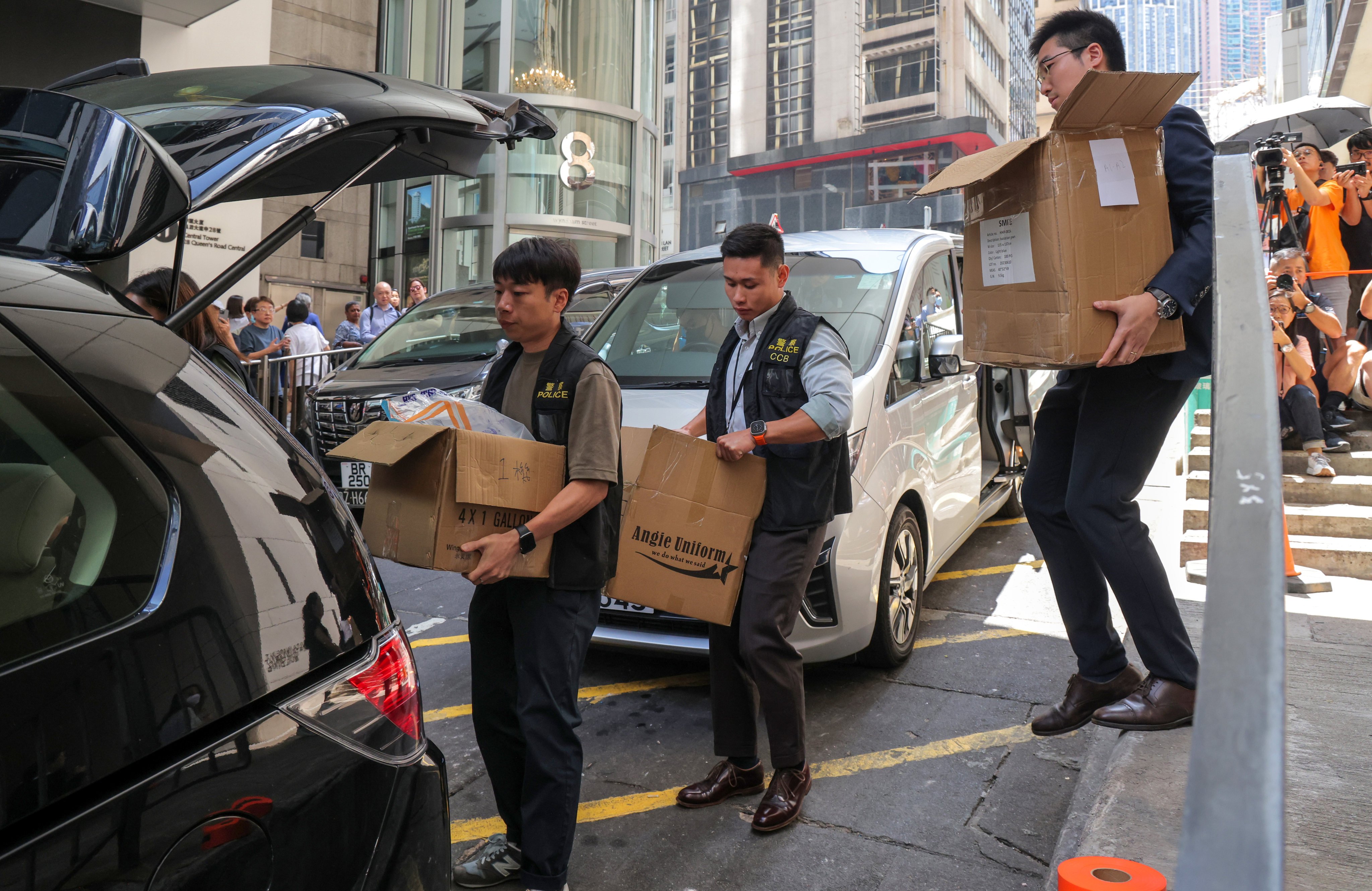 Police officers carry boxes out of a building in Central on September 18, in the wake of the JPEX scam. Photo: Jelly Tse