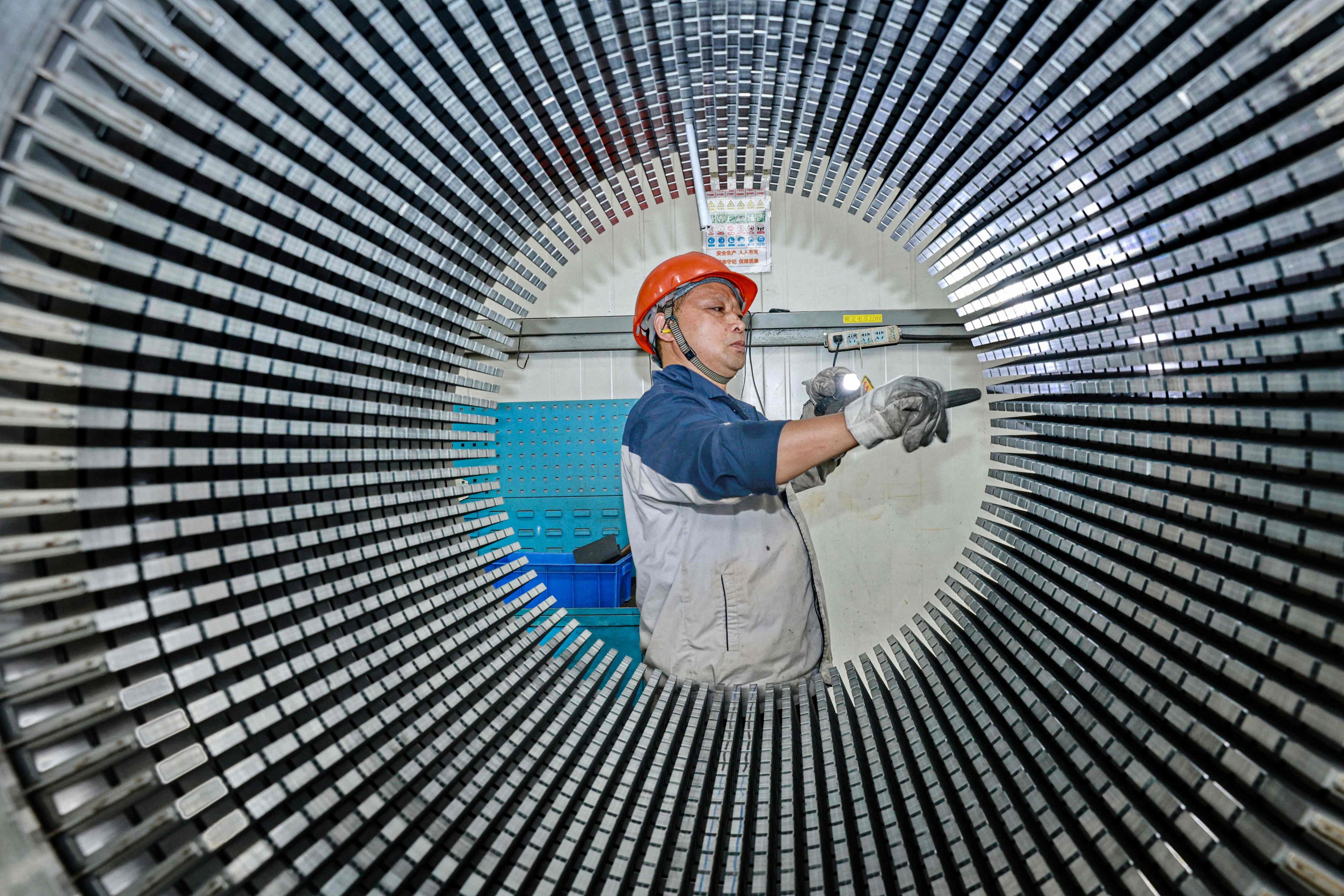 A worker checks a rotor core used for wind turbines at a factory in Nantong, in China’s eastern Jiangsu province. Photo: AFP