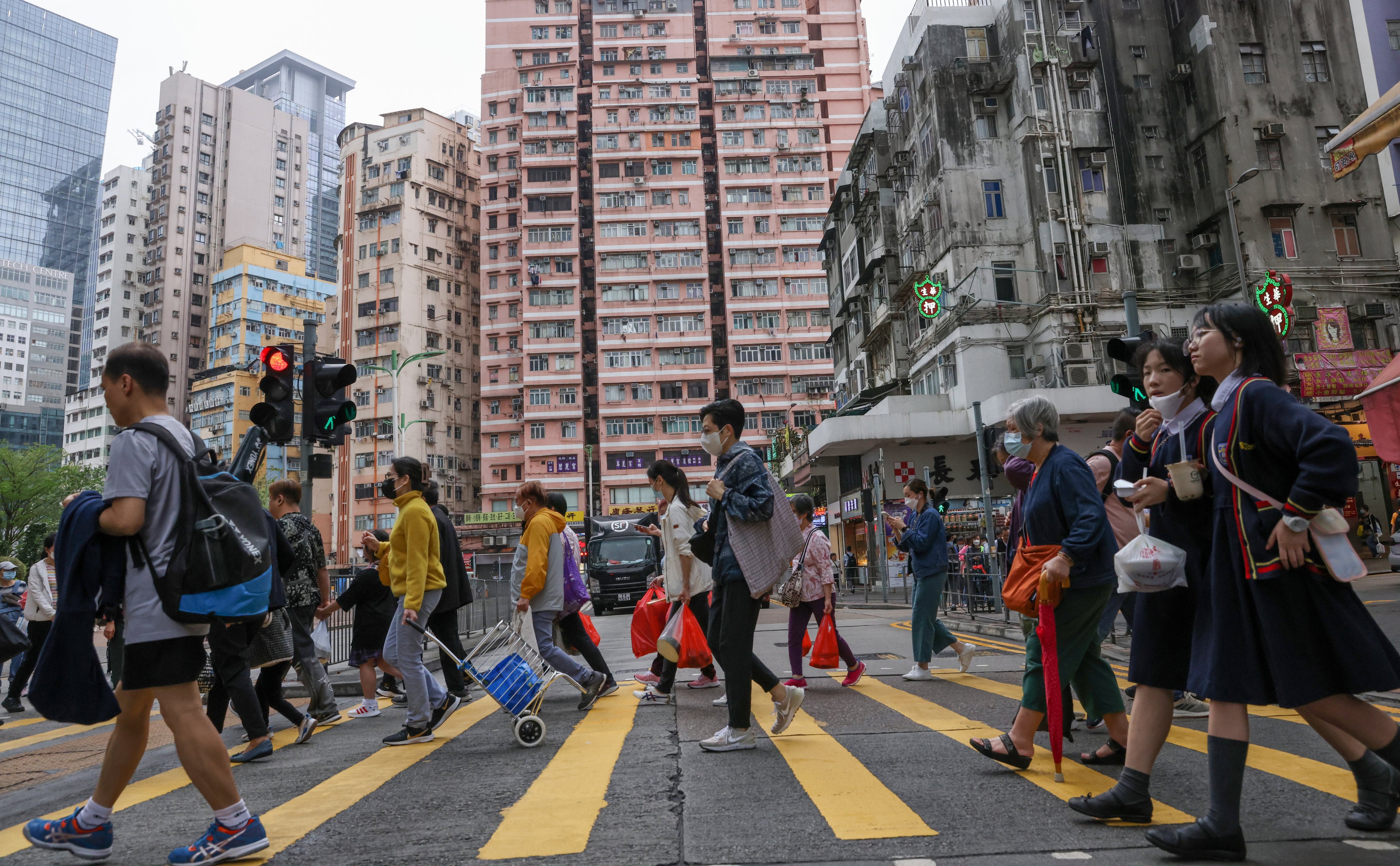 Pedestrians cross a road in Kwun Tong. Kwun Tong, which has replaced Sham Shui Po as the poorest district in the city, on April 4. Photo:   May Tse