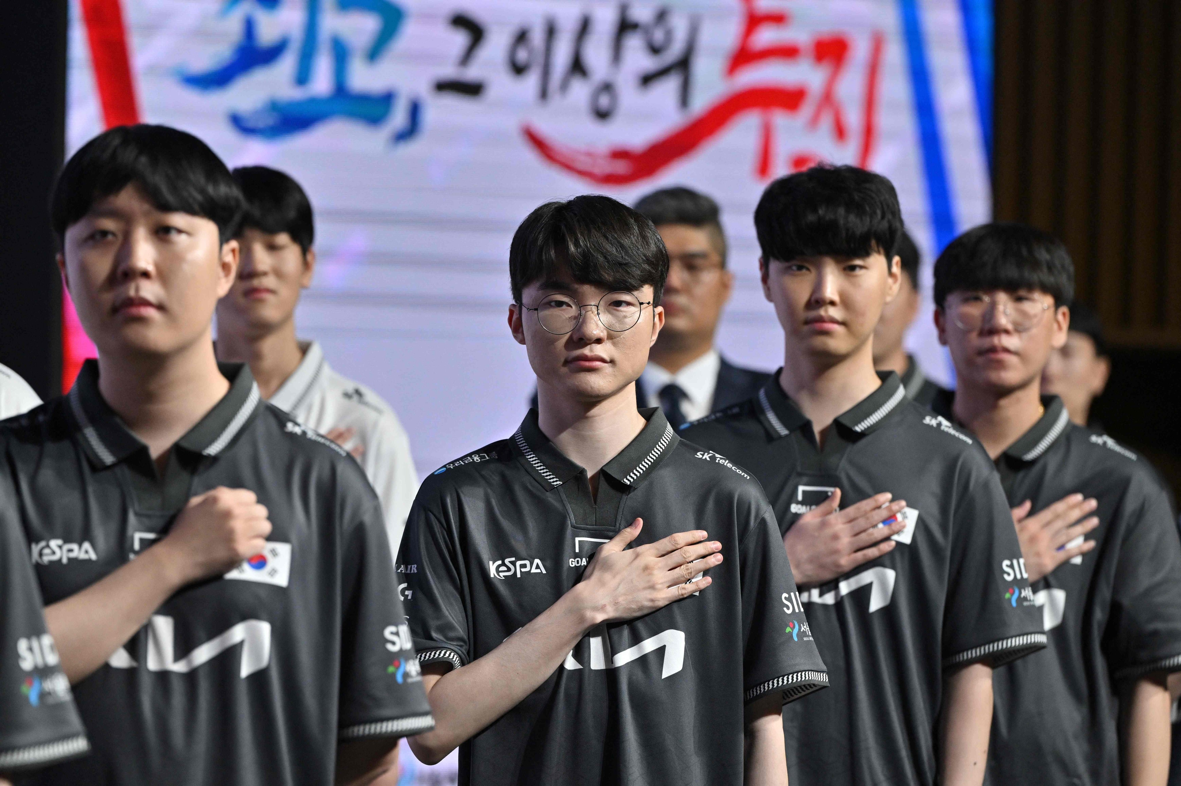 South Korean esports player Faker, left, and his colleagues salute the national flag at City Hall in Seoul on August 28. Photo: AFP 