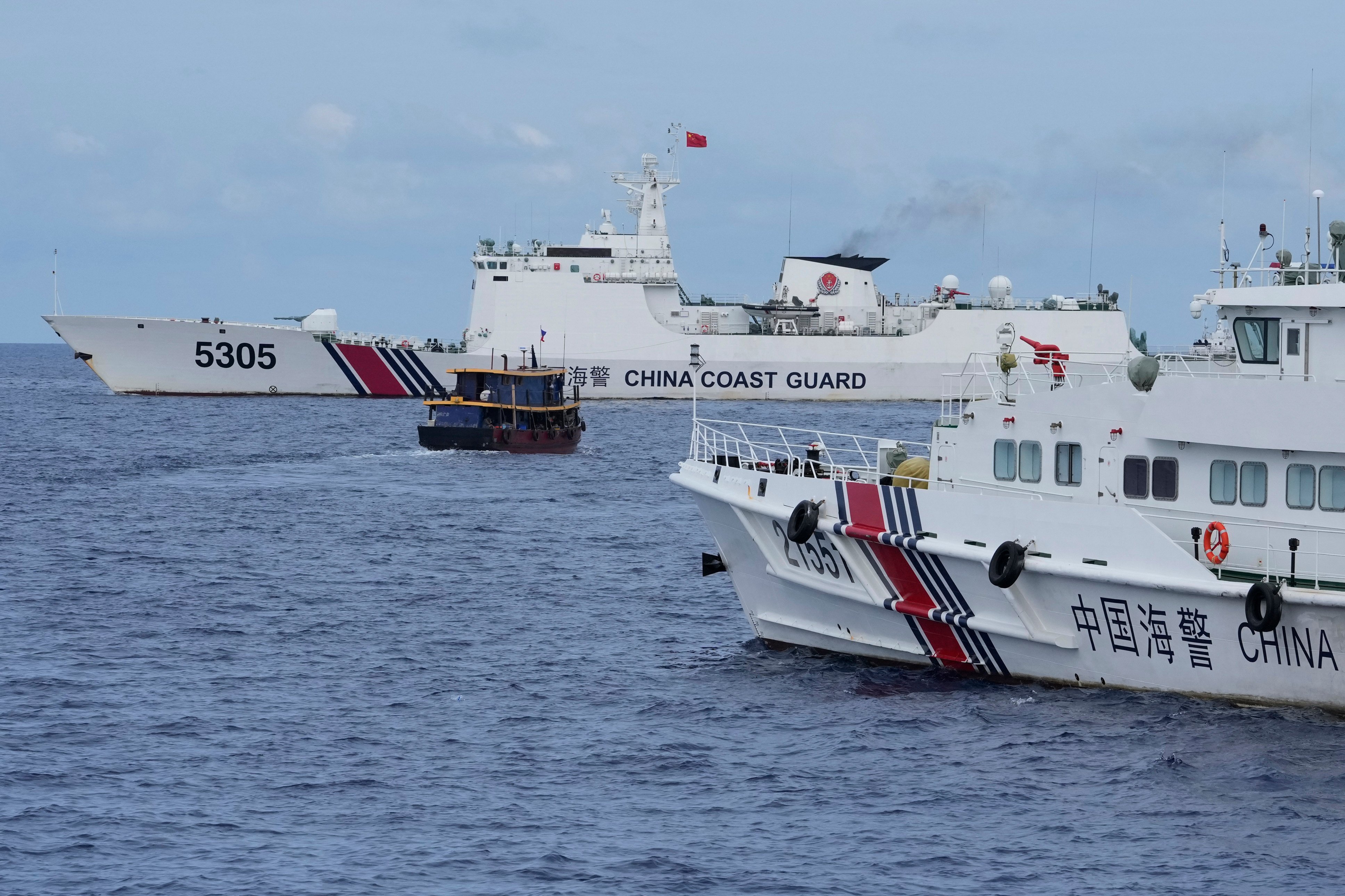 A Philippine supply boat, centre, manoeuvres around Chinese coast guard ships near the Second Thomas Shoal on August 22. Photo: AP