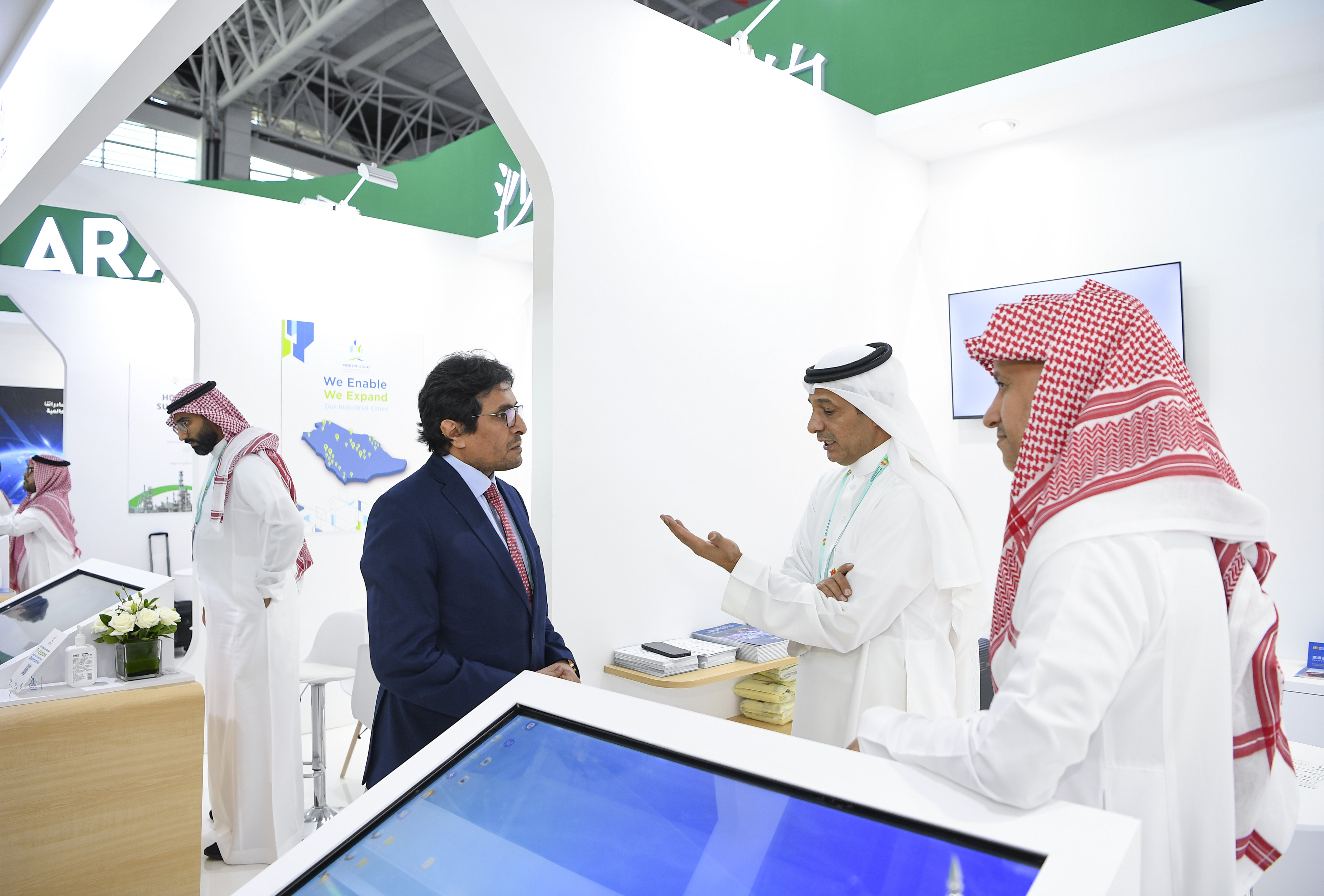 A guest talks with exhibitors at the Saudi booth during the expo. Photo: Xinhua