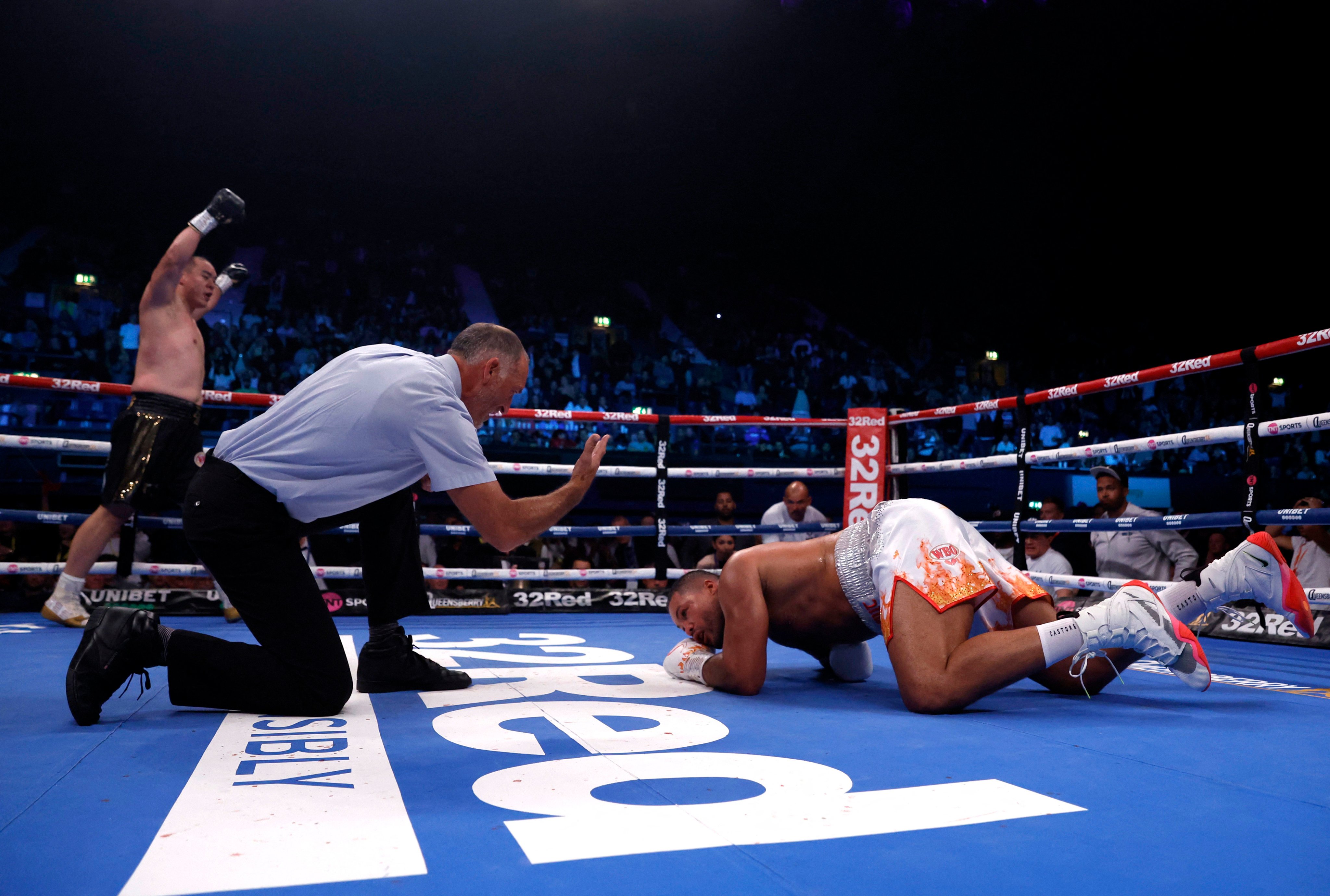 Joe Joyce is knocked down by Zhang Zhilei 
 in London. Photo: Action Images via Reuters
