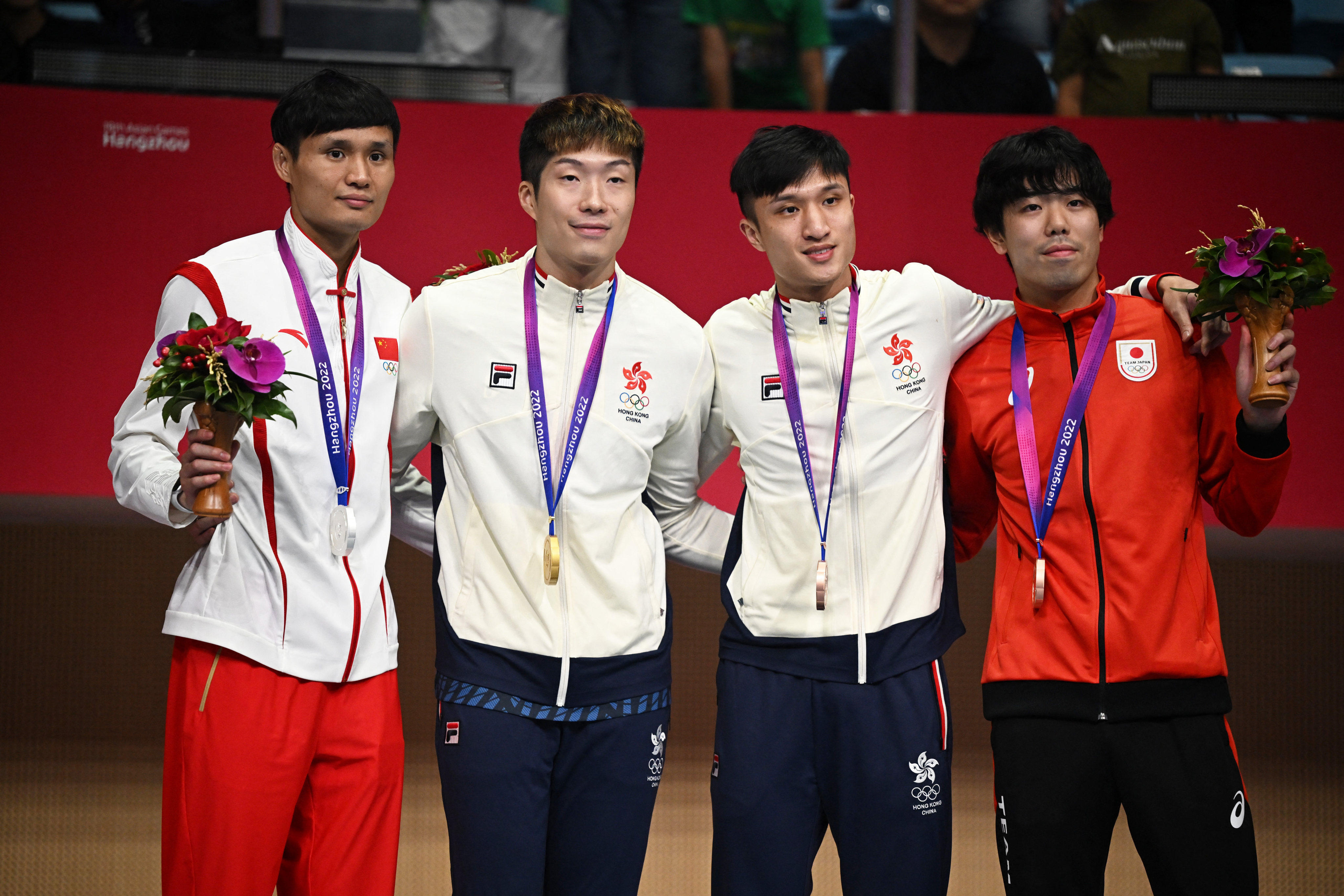 Hong Kong’s Cheung Ka-long celebrates on the podium alongside teammate Ryan Choi, and silver medallist Chen Haiwei (left) and the other bronze medallist, Takahiro. Photo: Reuters