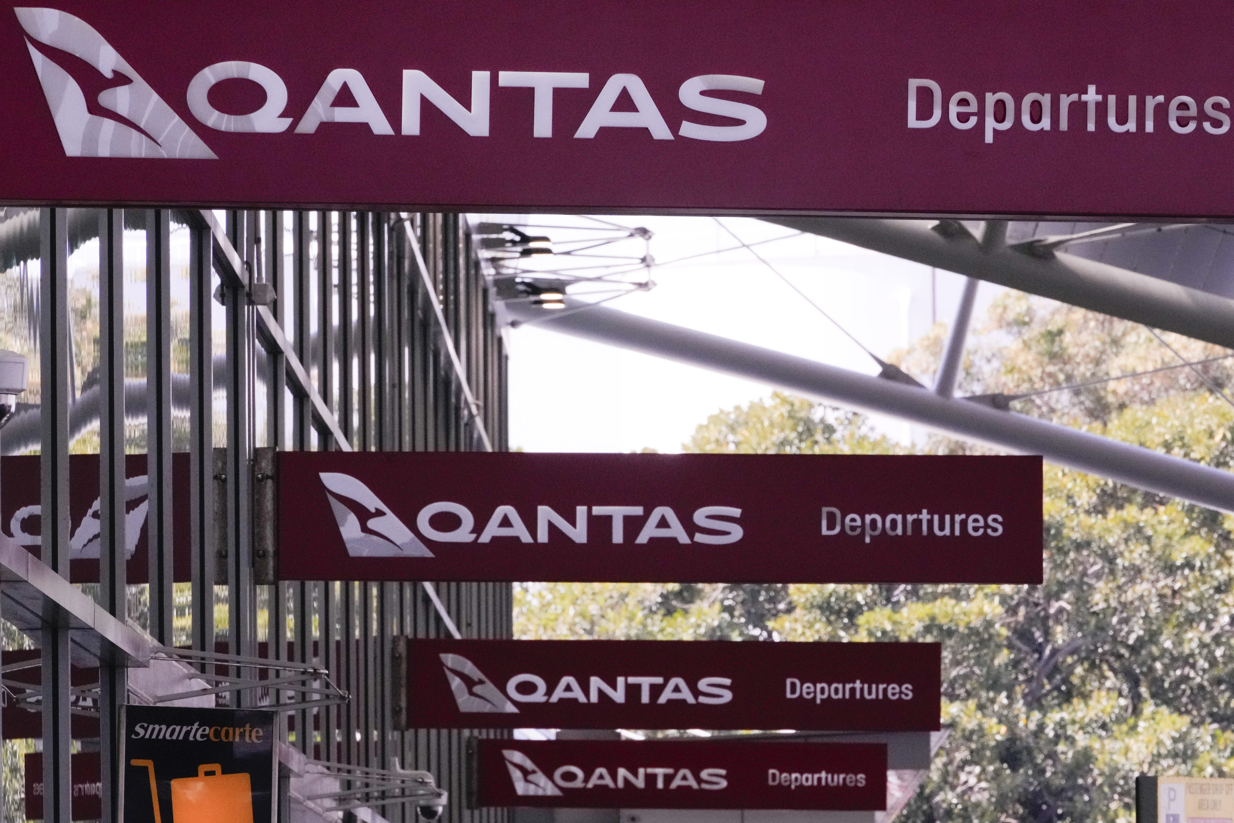Qantas signage outside a domestic terminal at Sydney Airport. The airline said on Monday that travel demand “remains strong”, even with its recent run of controversies. Photo: AP