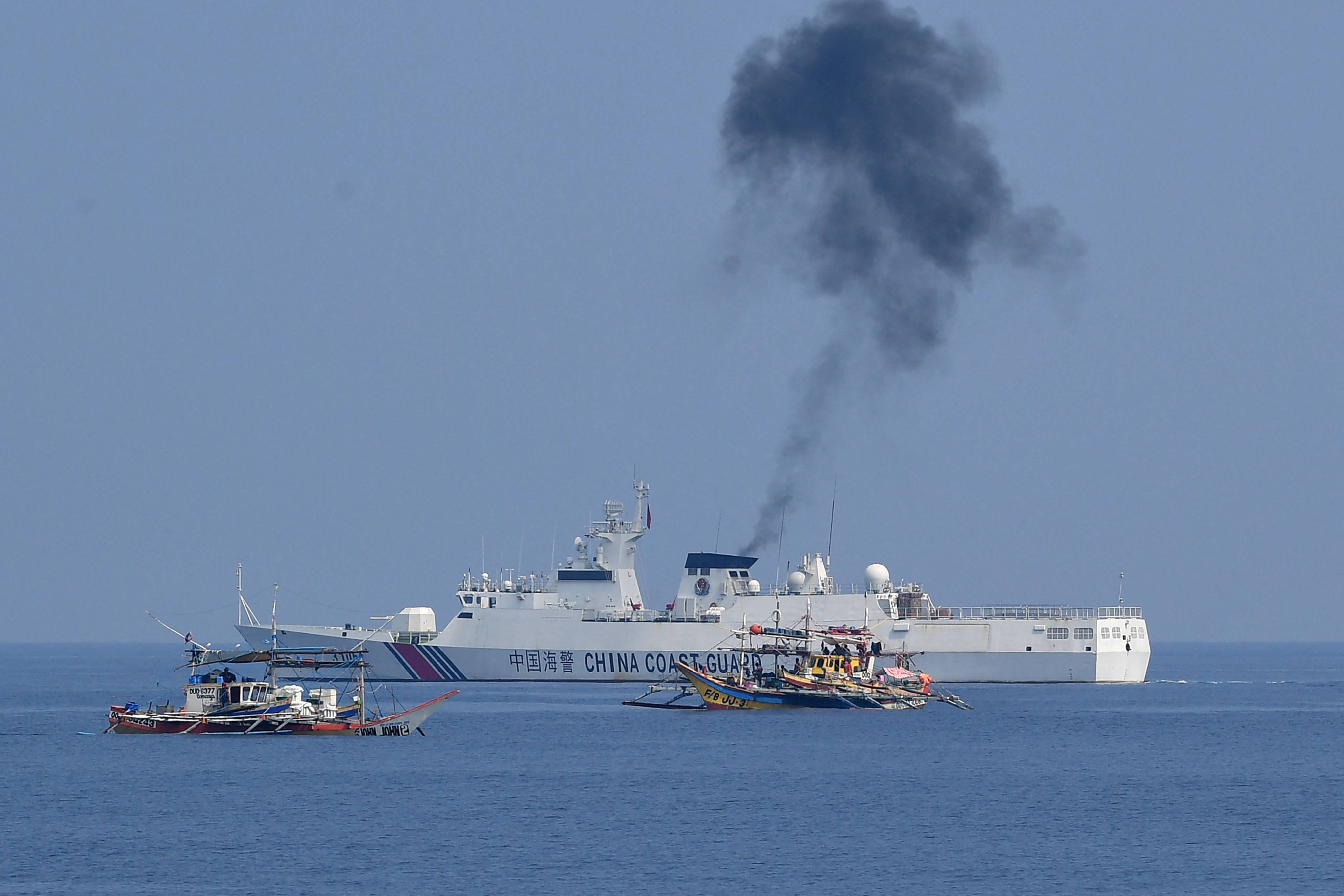 This photo taken on September 20, 2023 shows a Chinese coast guard ship (back) shadowing Philippine fishing boats anchored near the Chinese-controlled Scarborough Shoal in disputed waters of the South China Sea. Photo: AFP