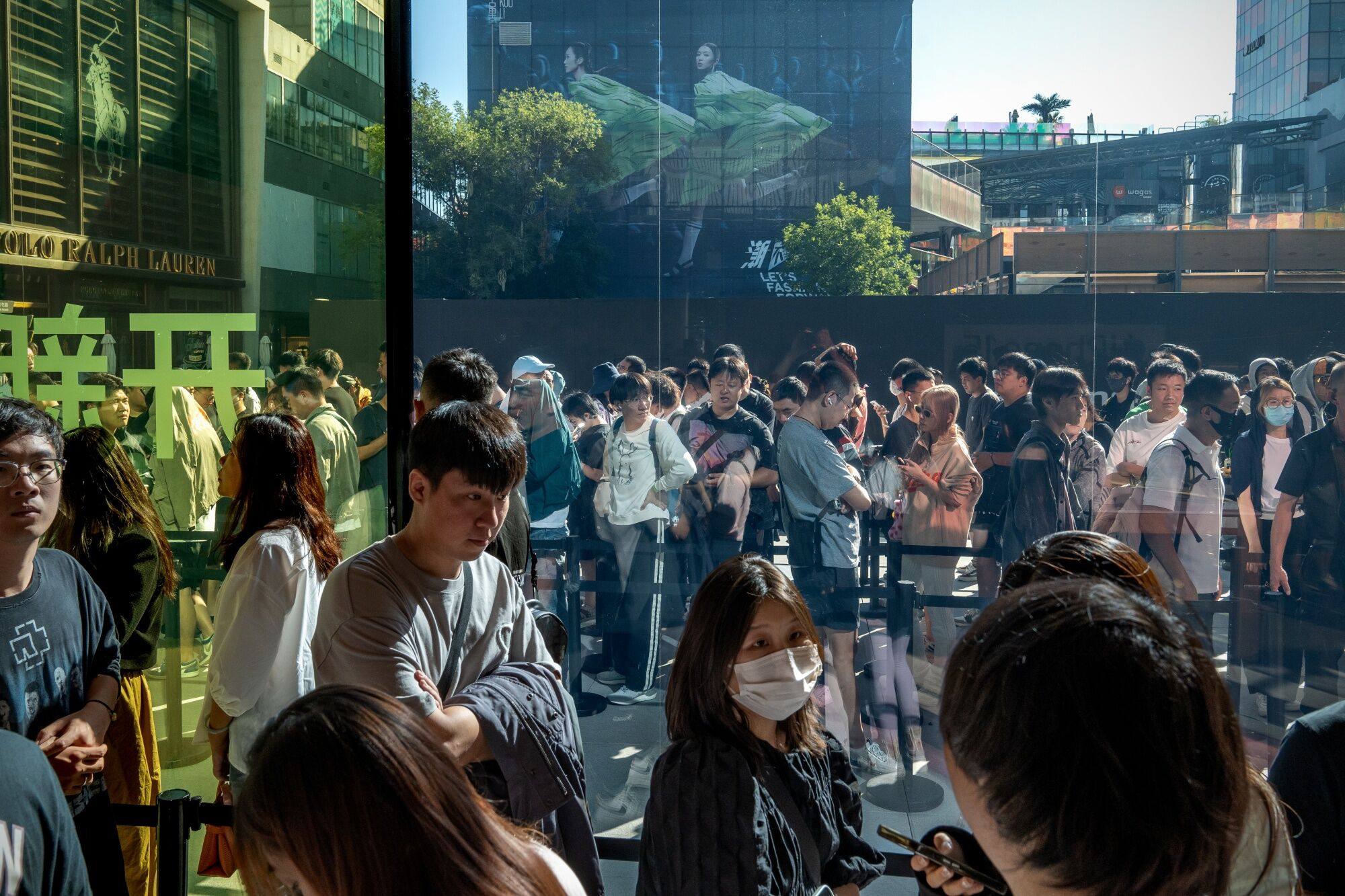 Customers queue at an Apple store in Beijing, on the first day of sale of the iPhone 15 smartphone on September 22. In boosting demand, China should focus on spurring domestic spending, whether by governments or households. Photo: Bloomberg