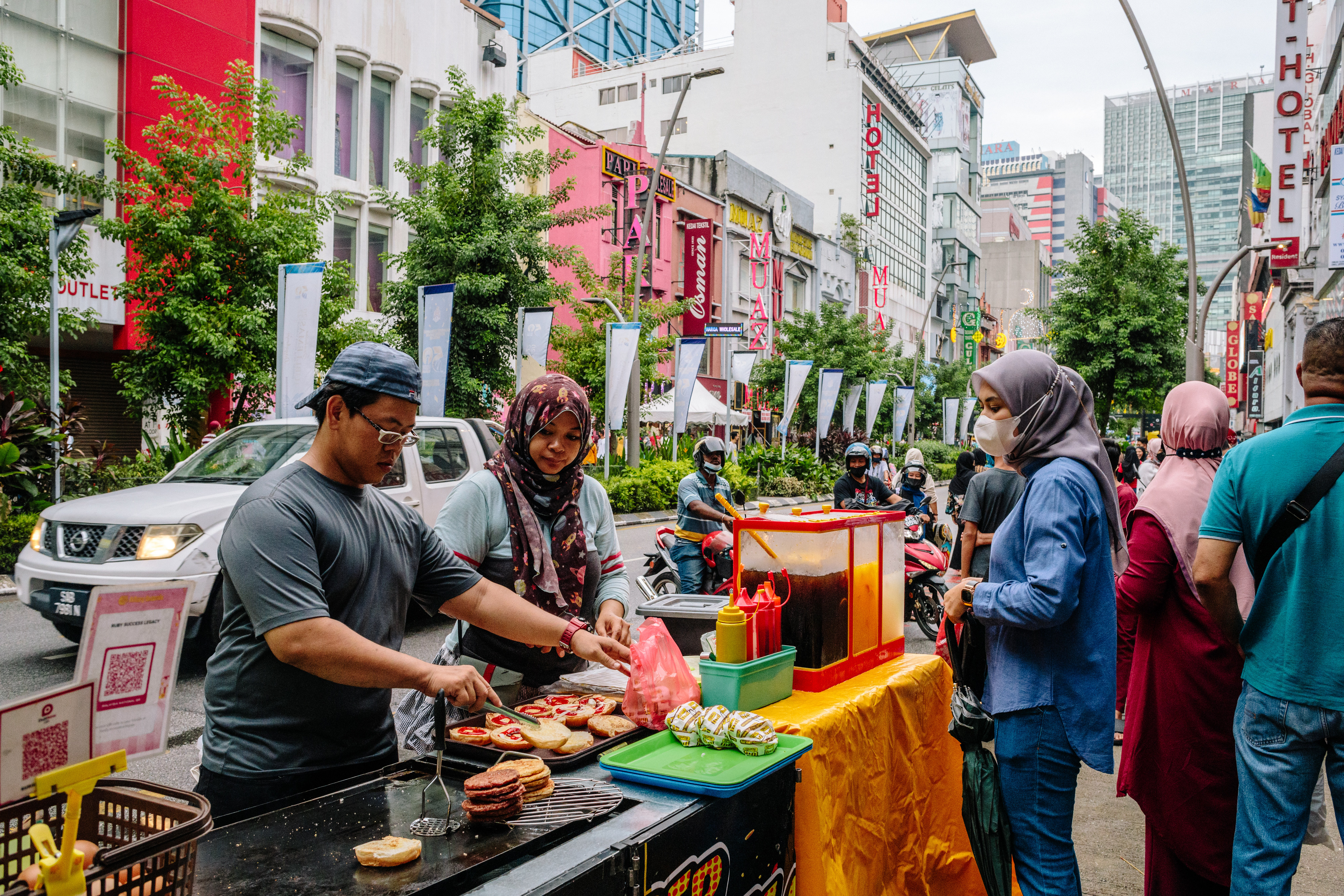 Food vendors serve a customer at a market in Kuala Lumpur. Photo: Bloomberg