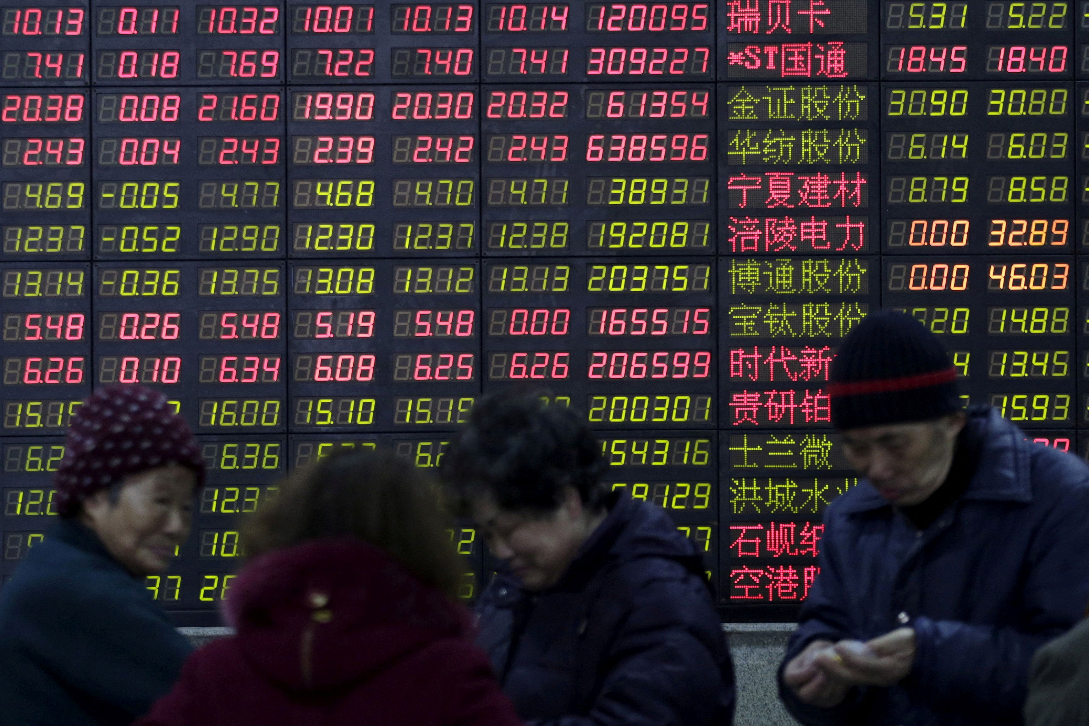 Investors in front of an electronic board showing stock information at a brokerage in Shanghai on February 15, 2016. Photo: Reuters.