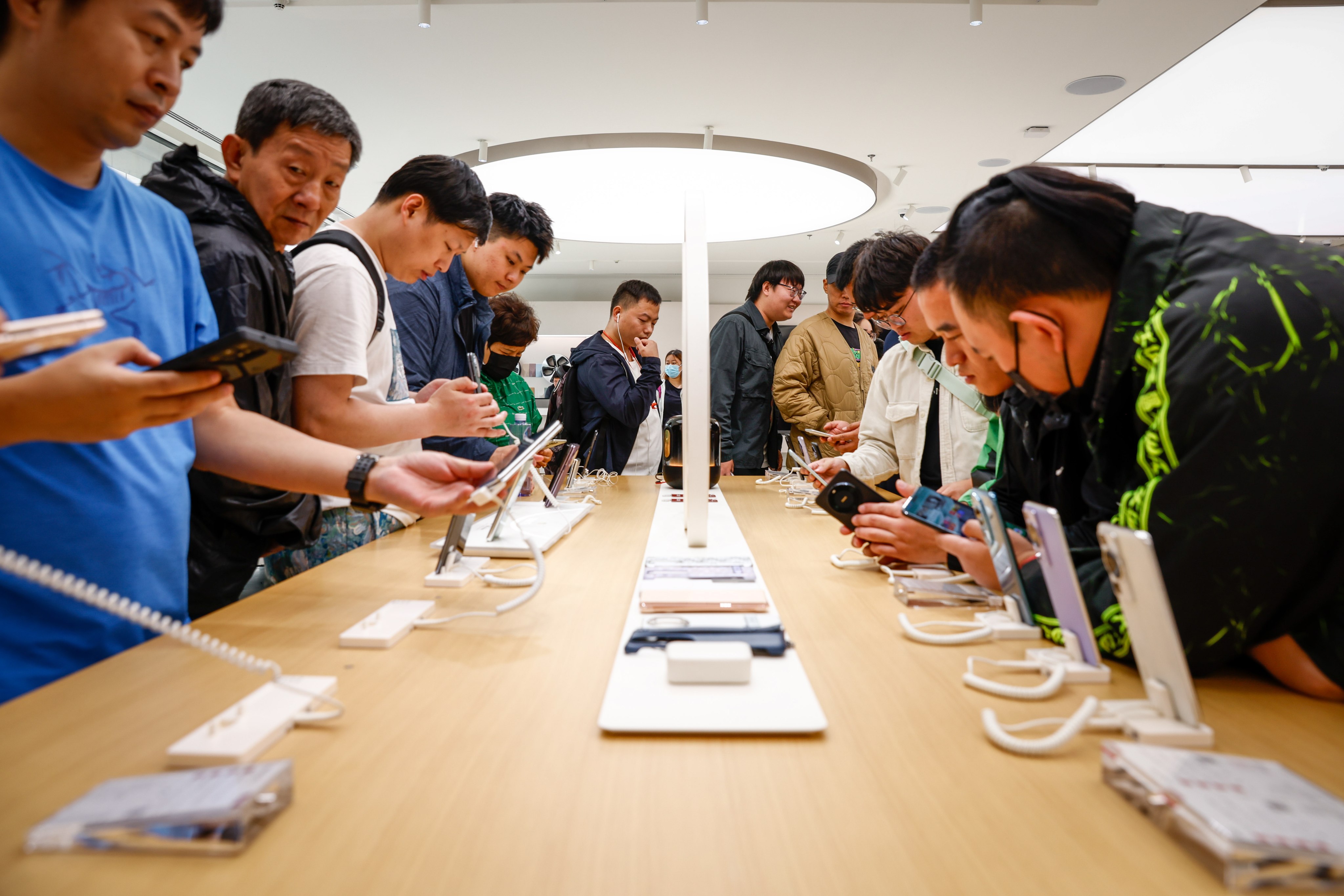 People check out the latest Huawei phone at a store in Beijing on September 25. It should come as no surprise that Huawei has responded strategically to America’s aggressive tactical campaign to restrict its core businesses and supply-chain dependencies. Photo: EPA-EFE
